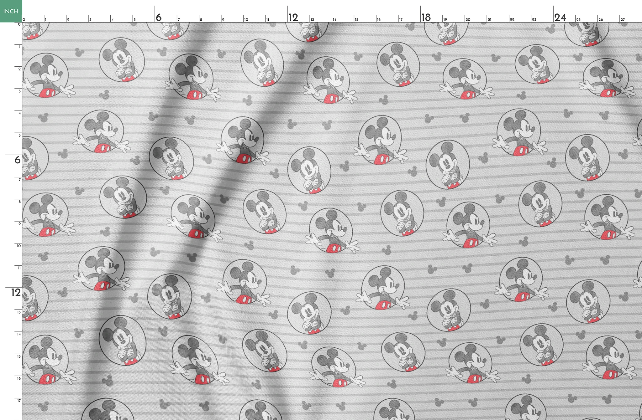 Mickey Mouse pattern on gray striped background with circular character portraits in red, black, and white springs fatquarter mockup