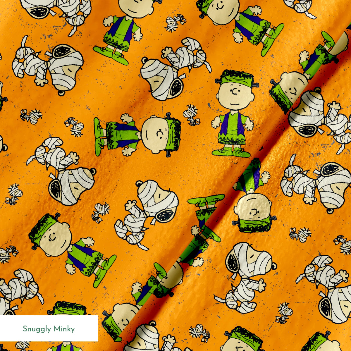Peanuts characters pattern on orange background with Charlie Brown, Snoopy, and friends scattered throughout springs minky texture