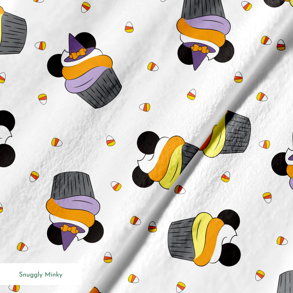 Disney cupcakes with black circular elements and colorful frosting in orange, yellow, and purple on a white background. springs minky texture