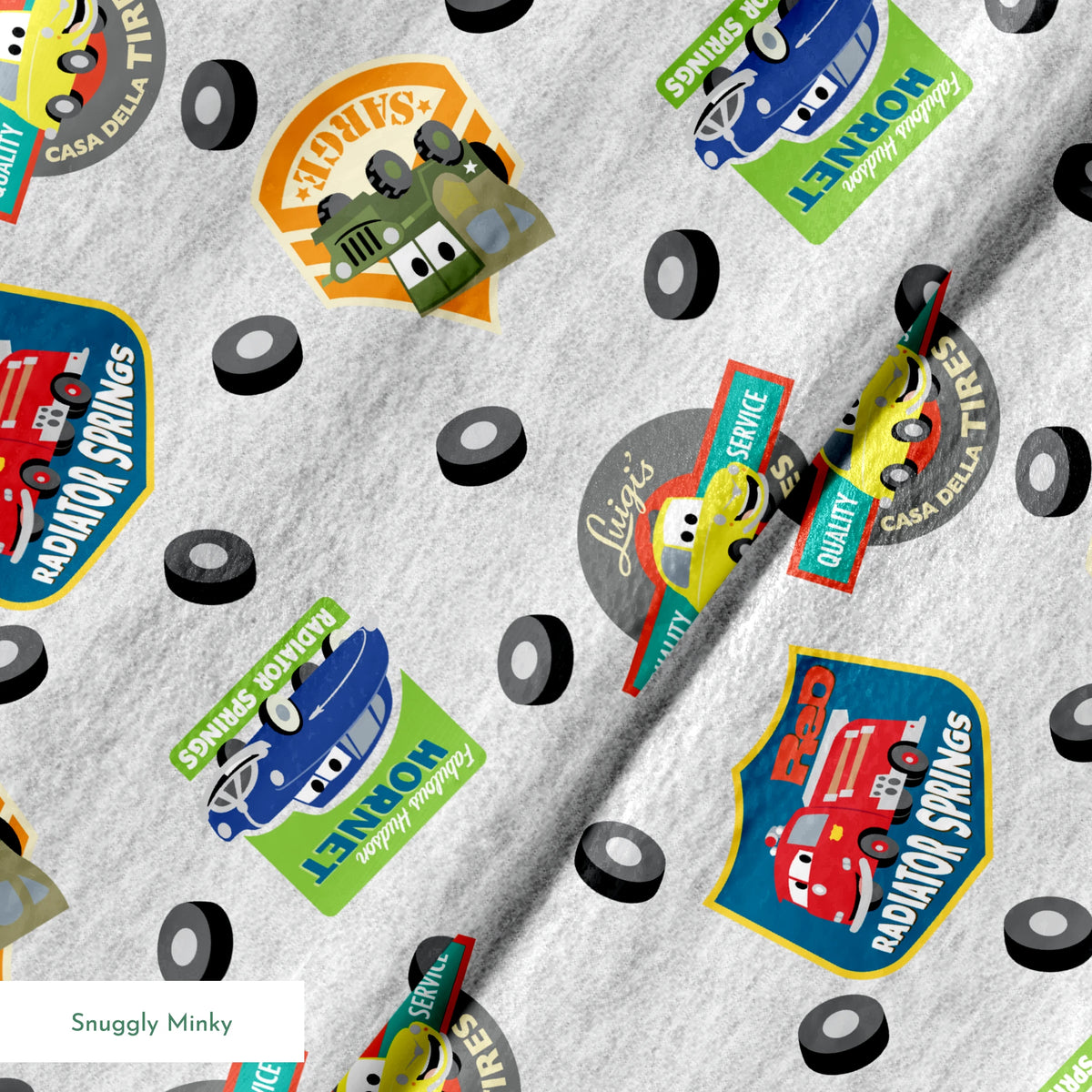 Cartoon vehicle characters on gray fabric with badges for Radiator Springs, Luigi's, and Sarge's springs minky texture