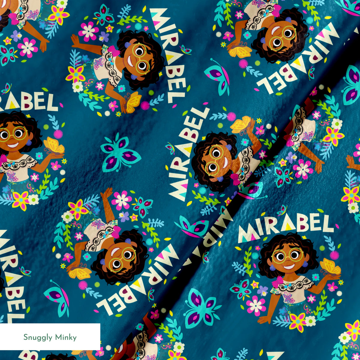 Colorful cartoon pattern on teal background featuring characters, butterflies, flowers, and "Mirabel" text in repeating design springs minky texture