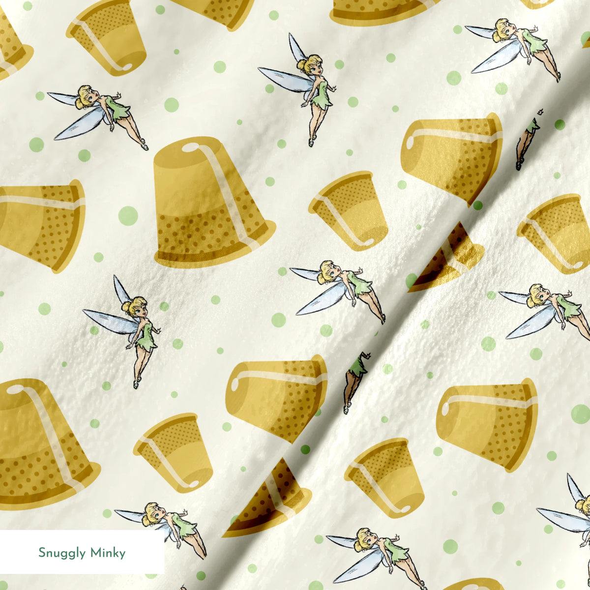 A pattern featuring Tinkerbell fairy with golden thimbles on a pale background with green dots. springs minky texture