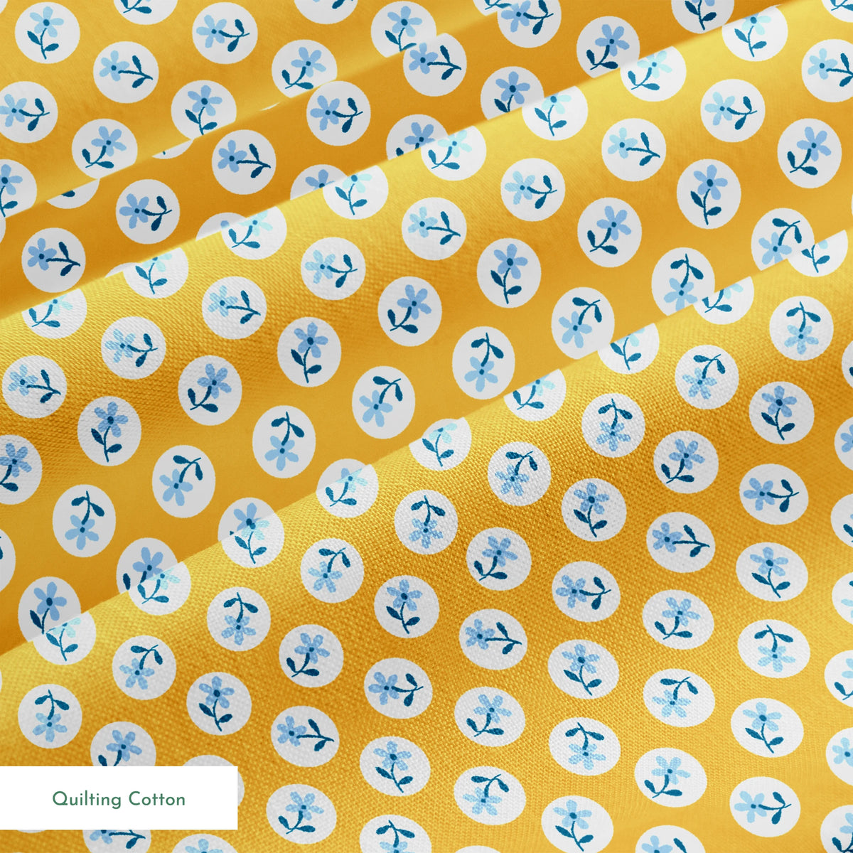 Light blue flowers with navy stems in white circles on a mustard yellow background springs quiltingcotton texture