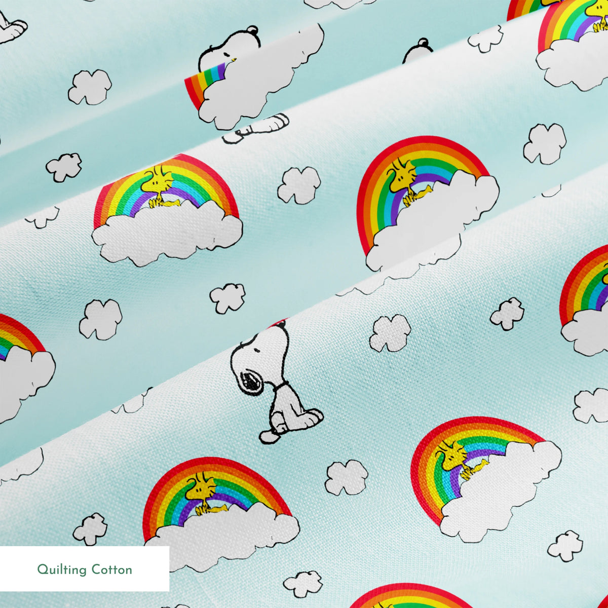 Snoopy and Woodstock characters on light blue background with rainbows, clouds and white fluffy clouds springs quiltingcotton texture