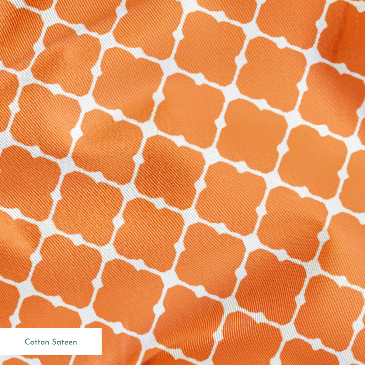 Geometric orange and white pattern with quatrefoil shapes forming a lattice design springs sateen texture