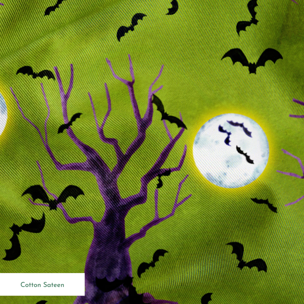Halloween fabric design with purple haunted trees, bats, and glowing moons on a green background, illustrated by Nicole Tamarin. springs sateen texture