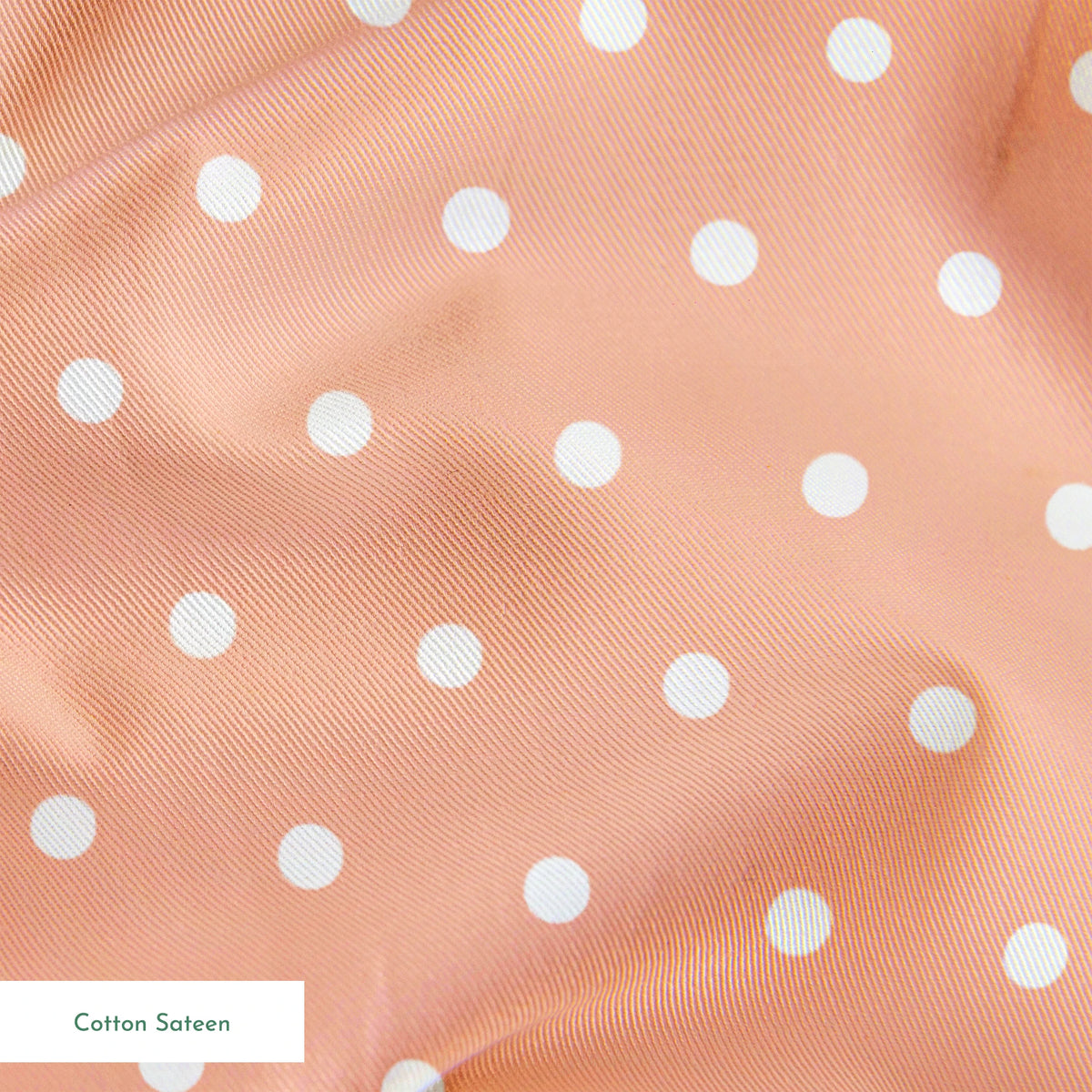 White circles on a peach/salmon colored background springs sateen texture