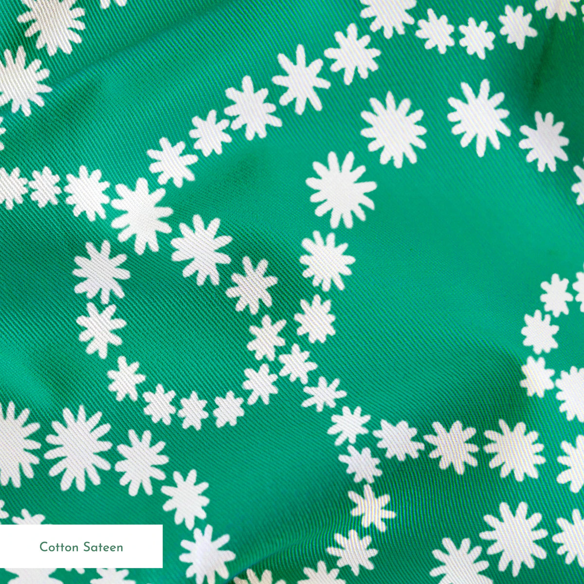 White dotted swirling patterns on green background forming abstract curving lines springs sateen texture