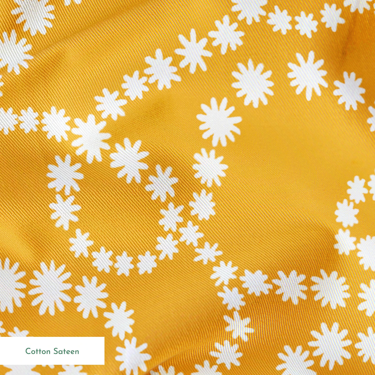 Mustard yellow background with swirling dotted white patterns forming organic circular designs springs sateen texture