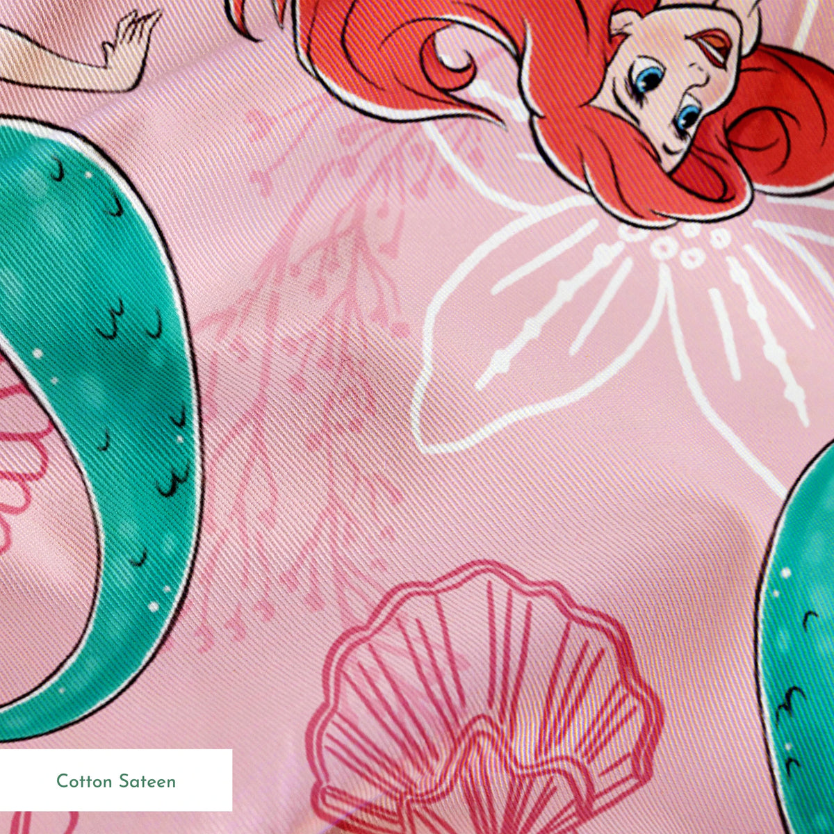 Illustrated pattern of mermaids with red hair and green tails swimming with yellow fish on pink seashell background springs sateen texture