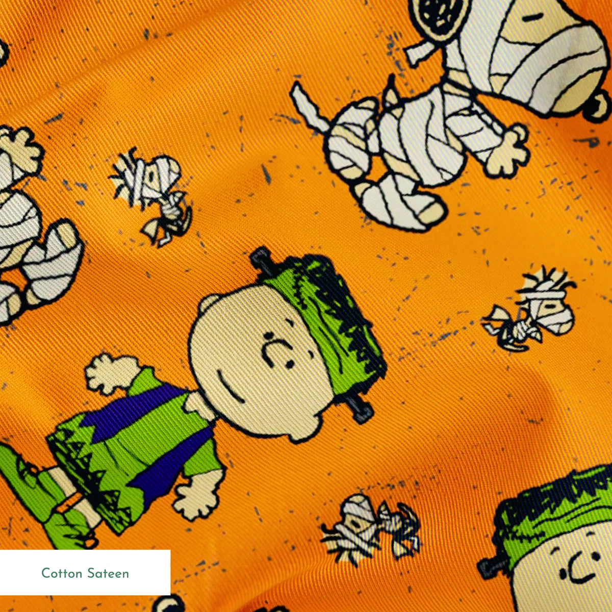 Peanuts characters pattern on orange background with Charlie Brown, Snoopy, and friends scattered throughout springs sateen texture