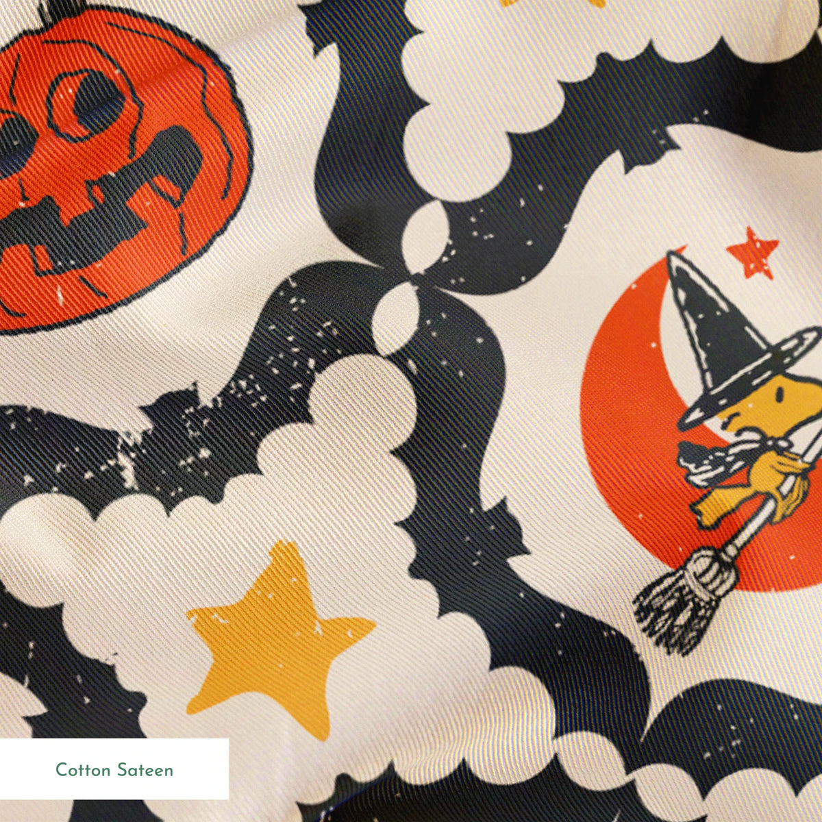 Peanuts Halloween pattern with orange jack-o'-lanterns, crescent moons with witch hats, yellow stars, and black bat borders on cream background springs sateen texture