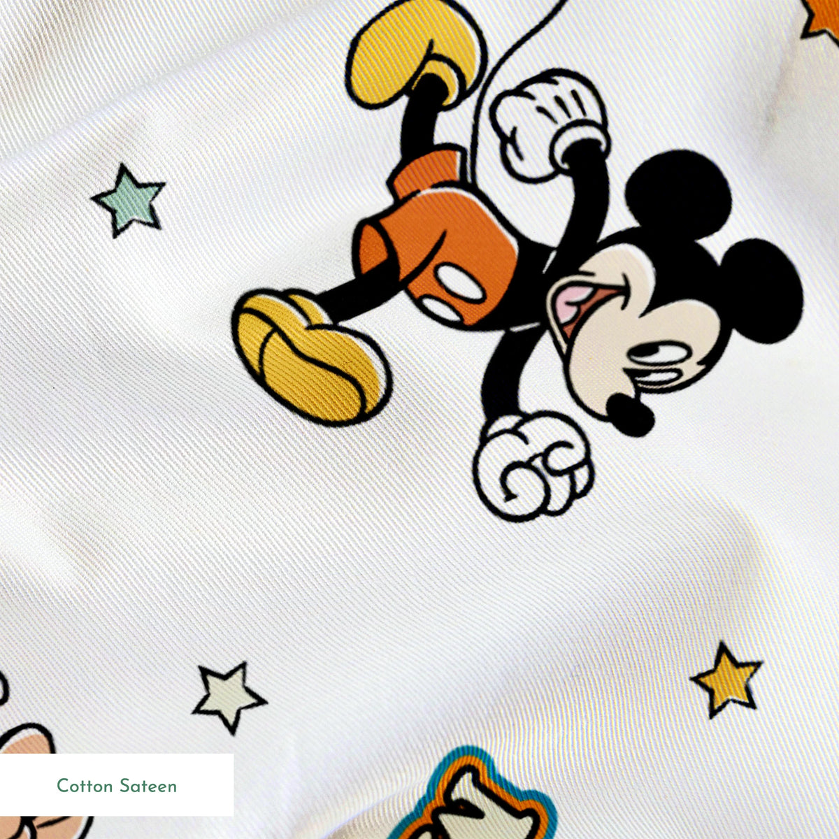 Pattern of cartoon Disney characters including Mickey Mouse and Minnie with yellow stars on white background springs sateen texture
