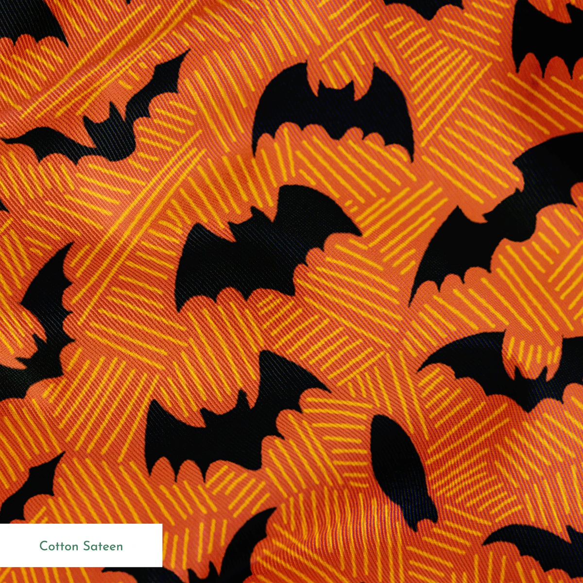 Halloween pattern with black bats scattered across an orange textured background springs sateen texture
