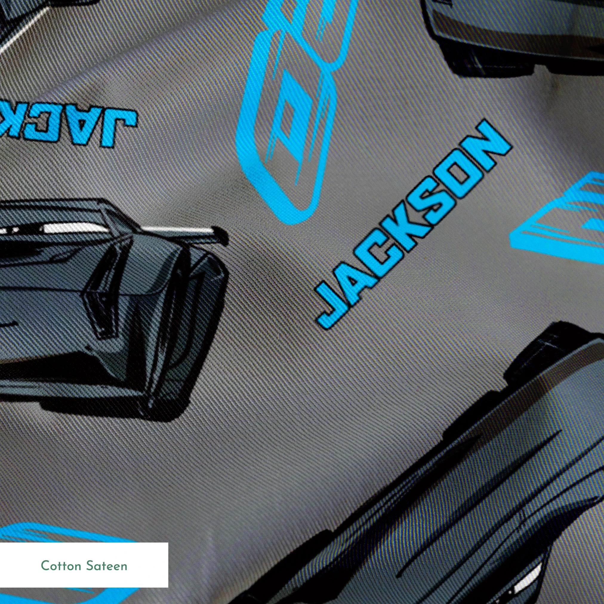 Dark gray background with scattered black car parts and blue "JACKSON" text and stylized logos in a repeating pattern springs sateen texture