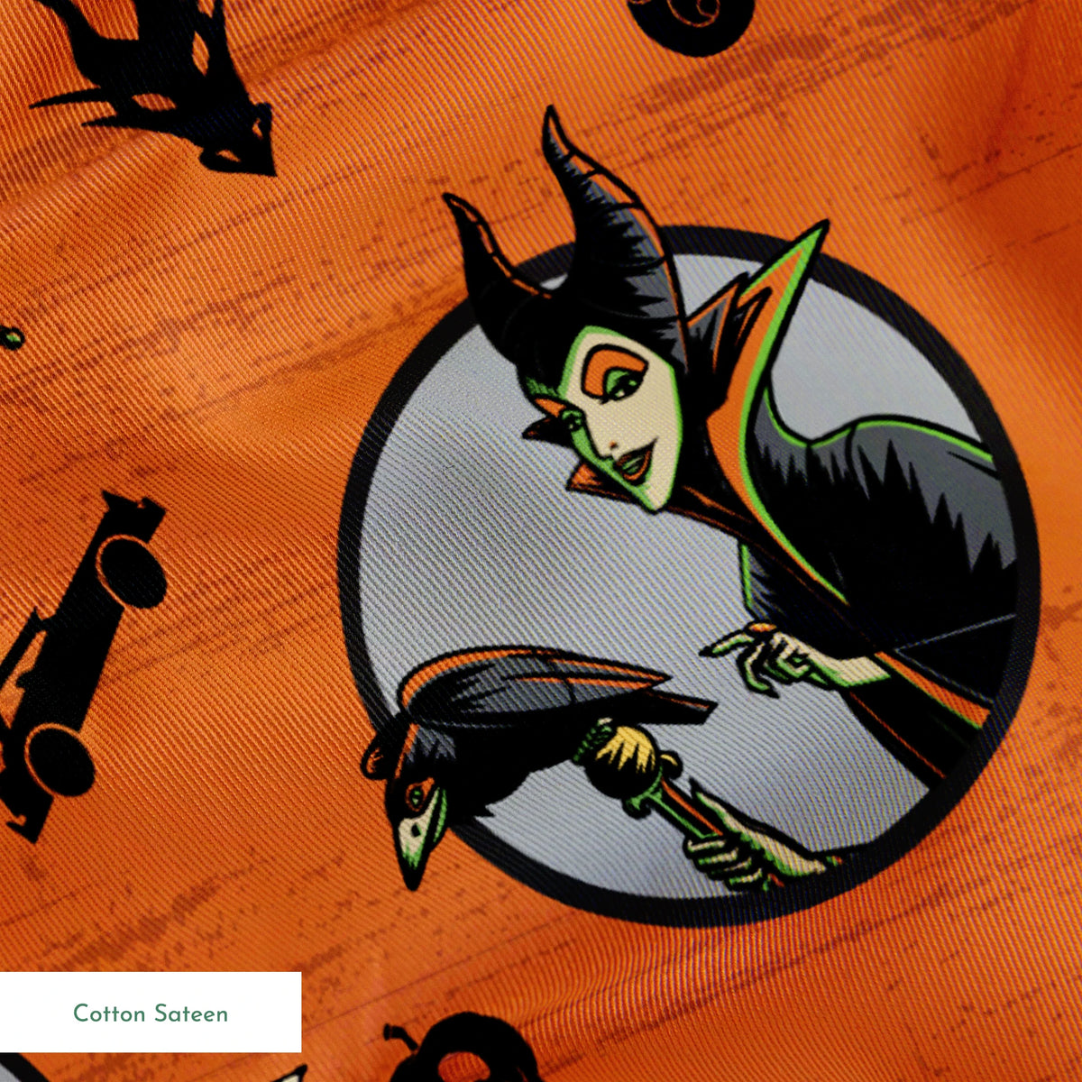 Halloween-themed orange pattern with circular Disney Villain portraits, black cats, bats, pumpkins, and spooky symbols springs sateen texture