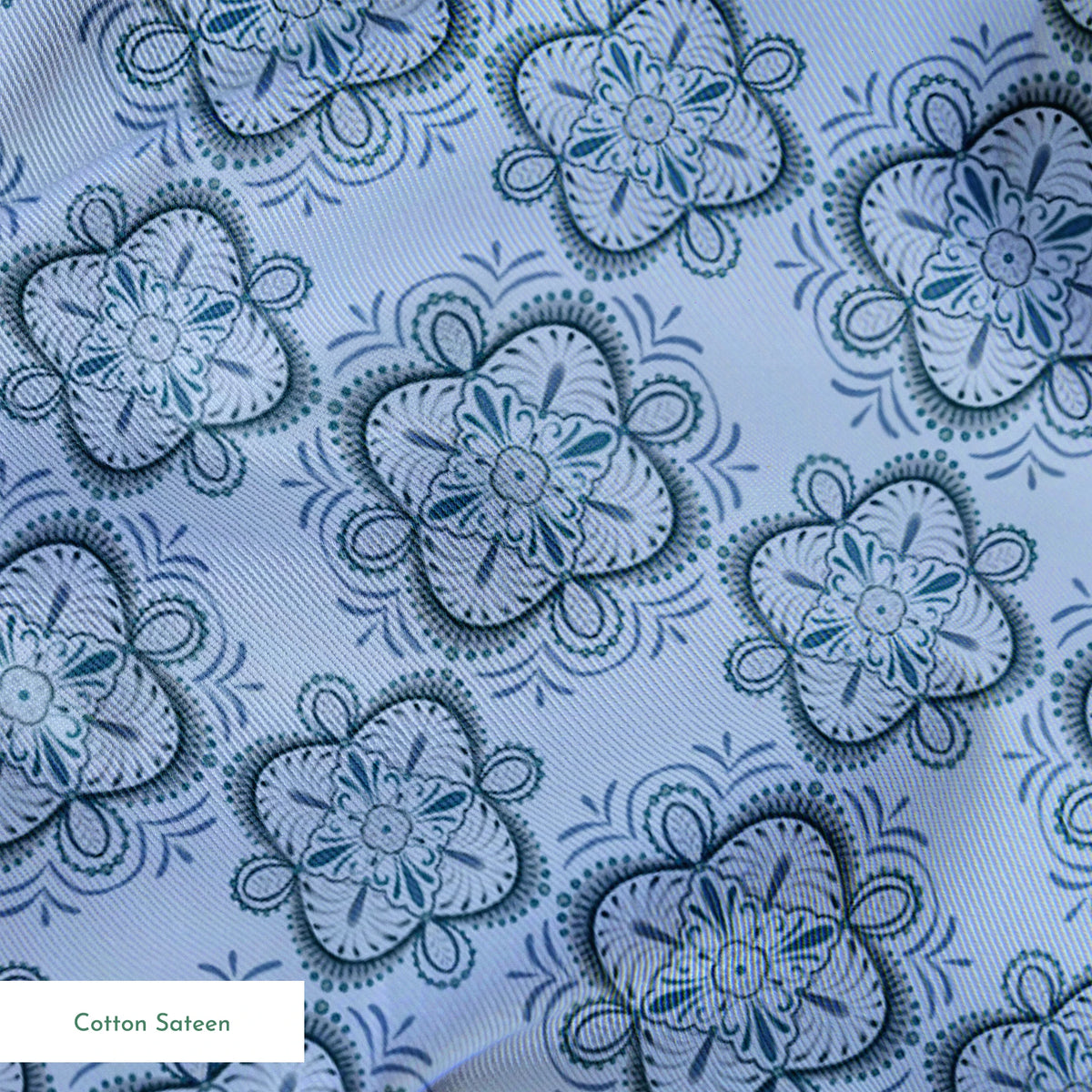 Symmetrical floral mandala pattern in layered blue tones with hand-drawn botanical details, designed by Nicole Tamarin. springs sateen texture