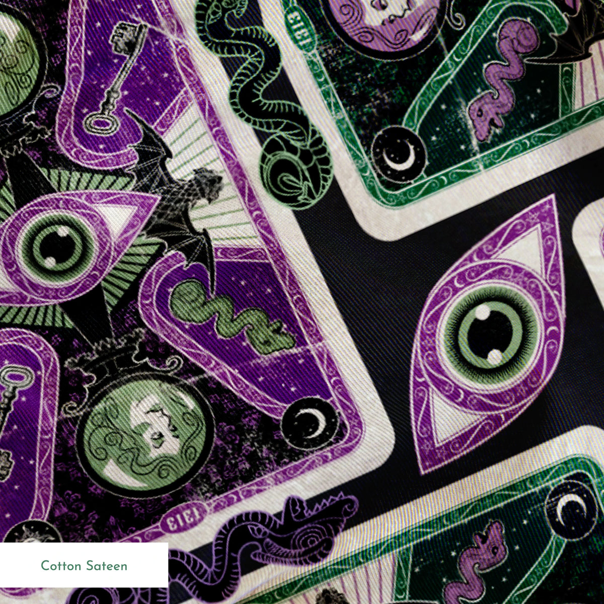 Ornate playing card designs with purple and green patterns featuring central eye motifs and circular number elements against a black background. springs sateen texture