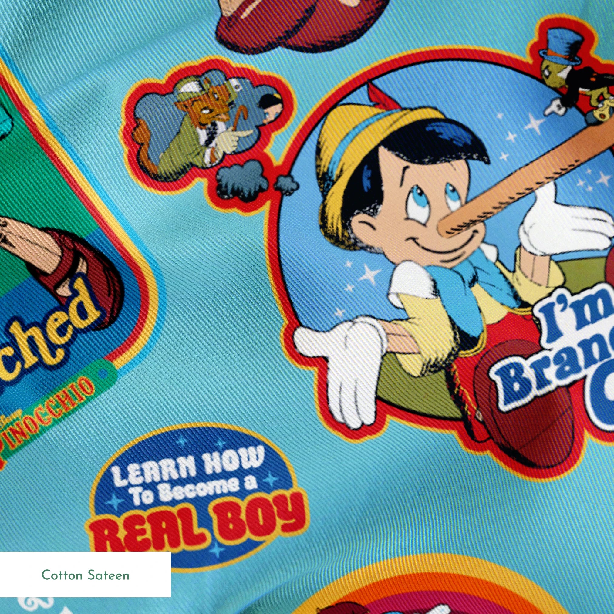 Colorful Pinocchio cartoon pattern featuring puppet characters, slogans, and red apples on teal background springs sateen texture
