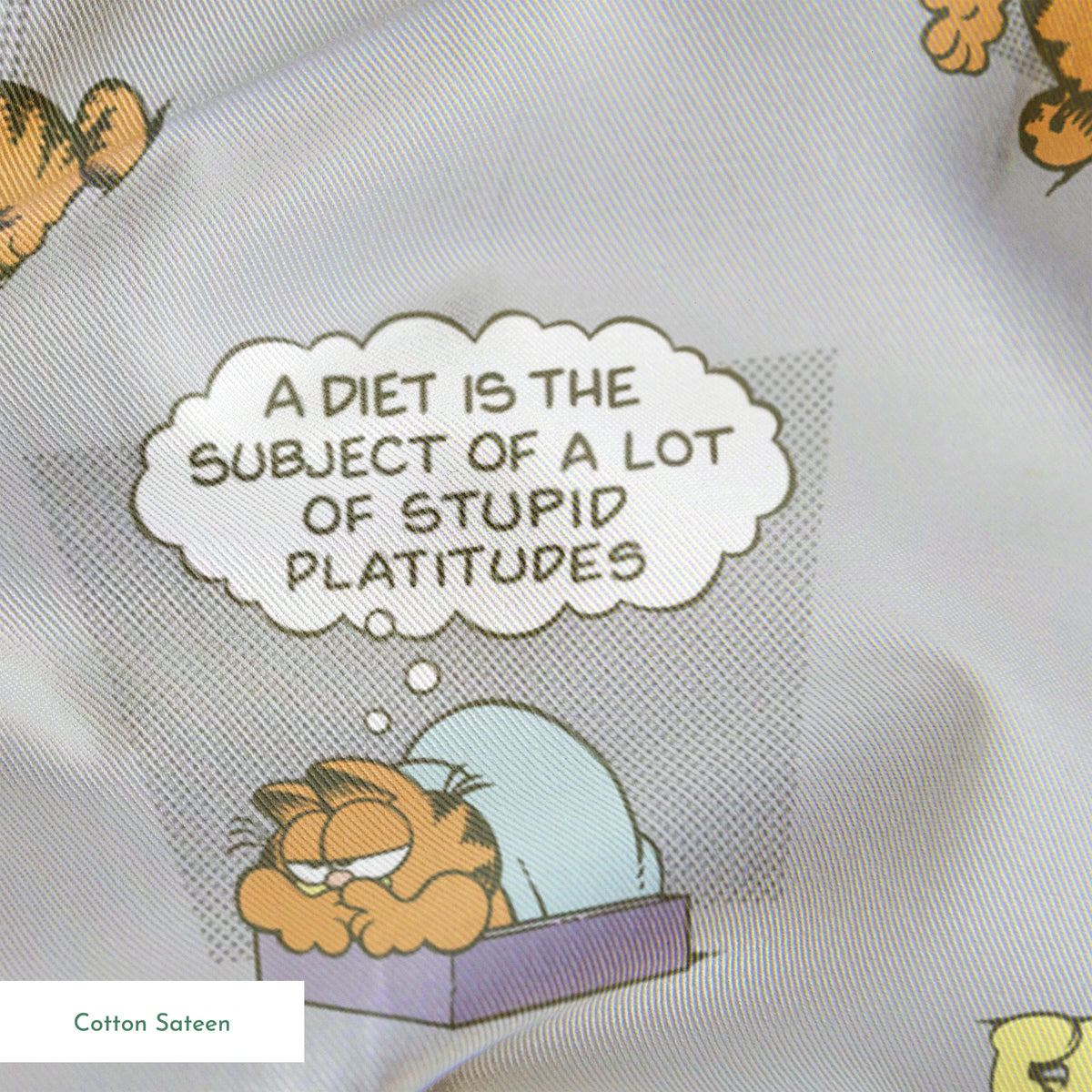 Cartoon Garfield pattern with various poses of the orange cat and speech bubbles on gray background springs sateen texture