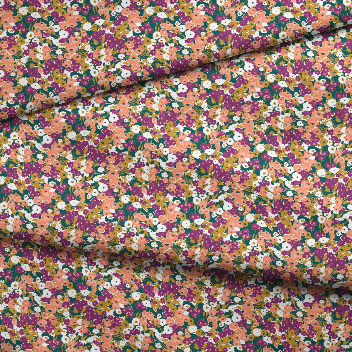 Vibrant floral pattern with peach, purple, white, and gold blooms against dark green foliage fabric fold mockup