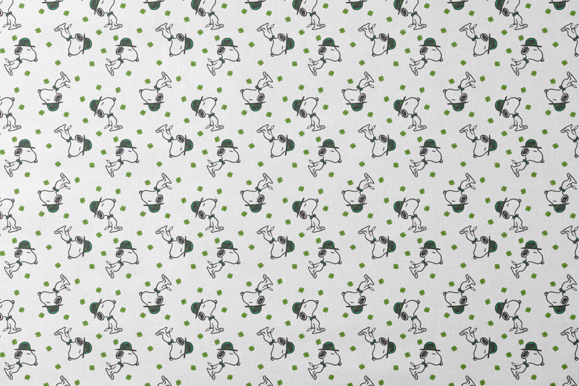 Cartoon Snoopy wearing green hat with shamrocks scattered across white background designs flat mockup