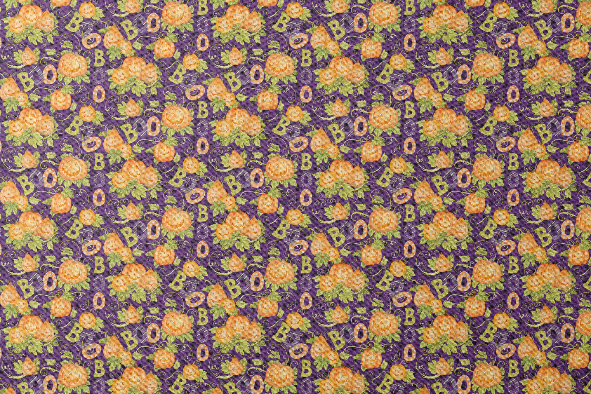 Halloween fabric by Nicole Tamarin with smiling jack-o’-lanterns, “BOO” text, vines, and leaves on a purple background. designs flat mockup