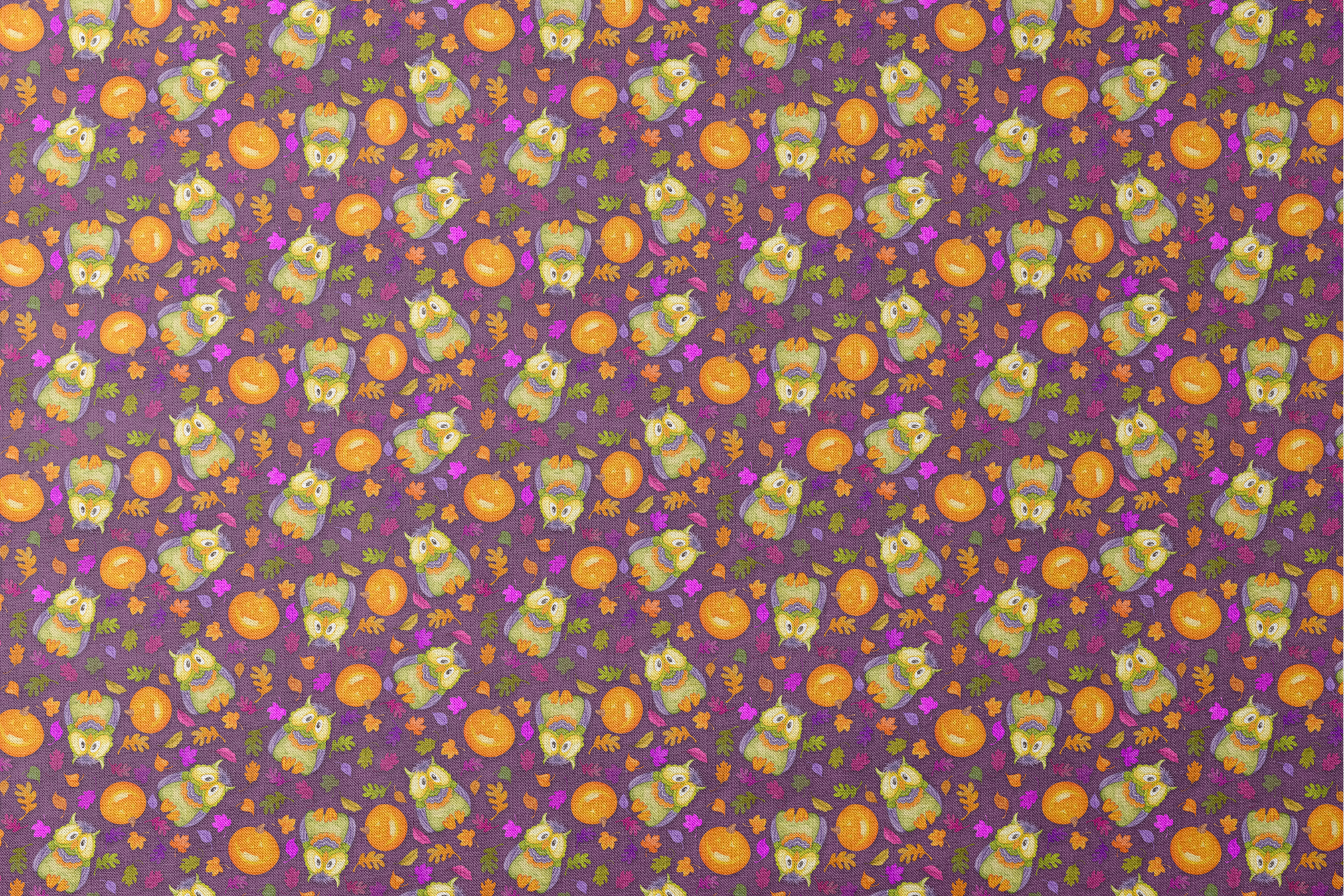 Halloween fabric by Nicole Tamarin featuring cartoon owls in costume, jack-o’-lanterns, and colorful fall leaves on a purple background. designs flat mockup