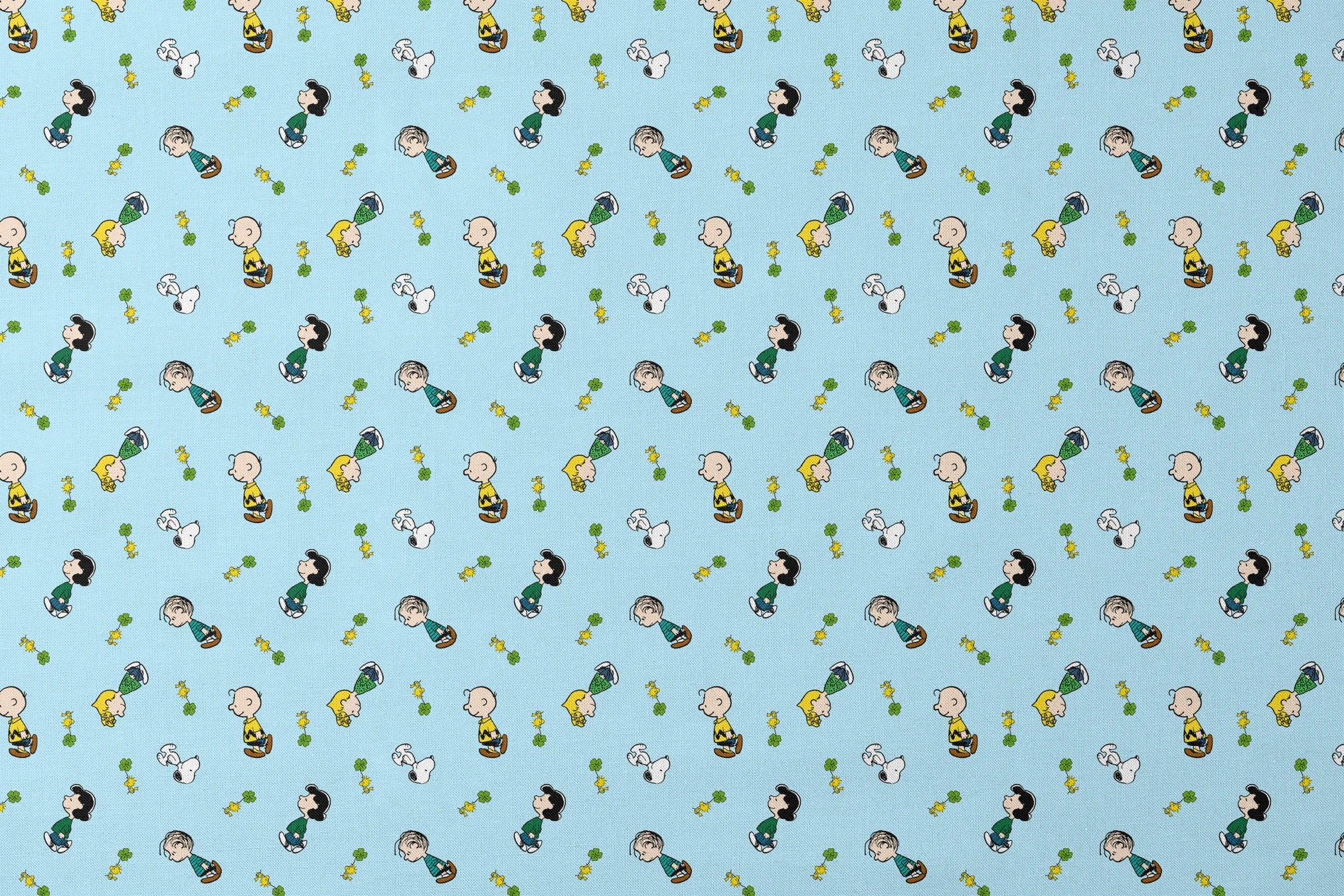 Peanuts cartoon characters on light blue background with clovers designs flat mockup