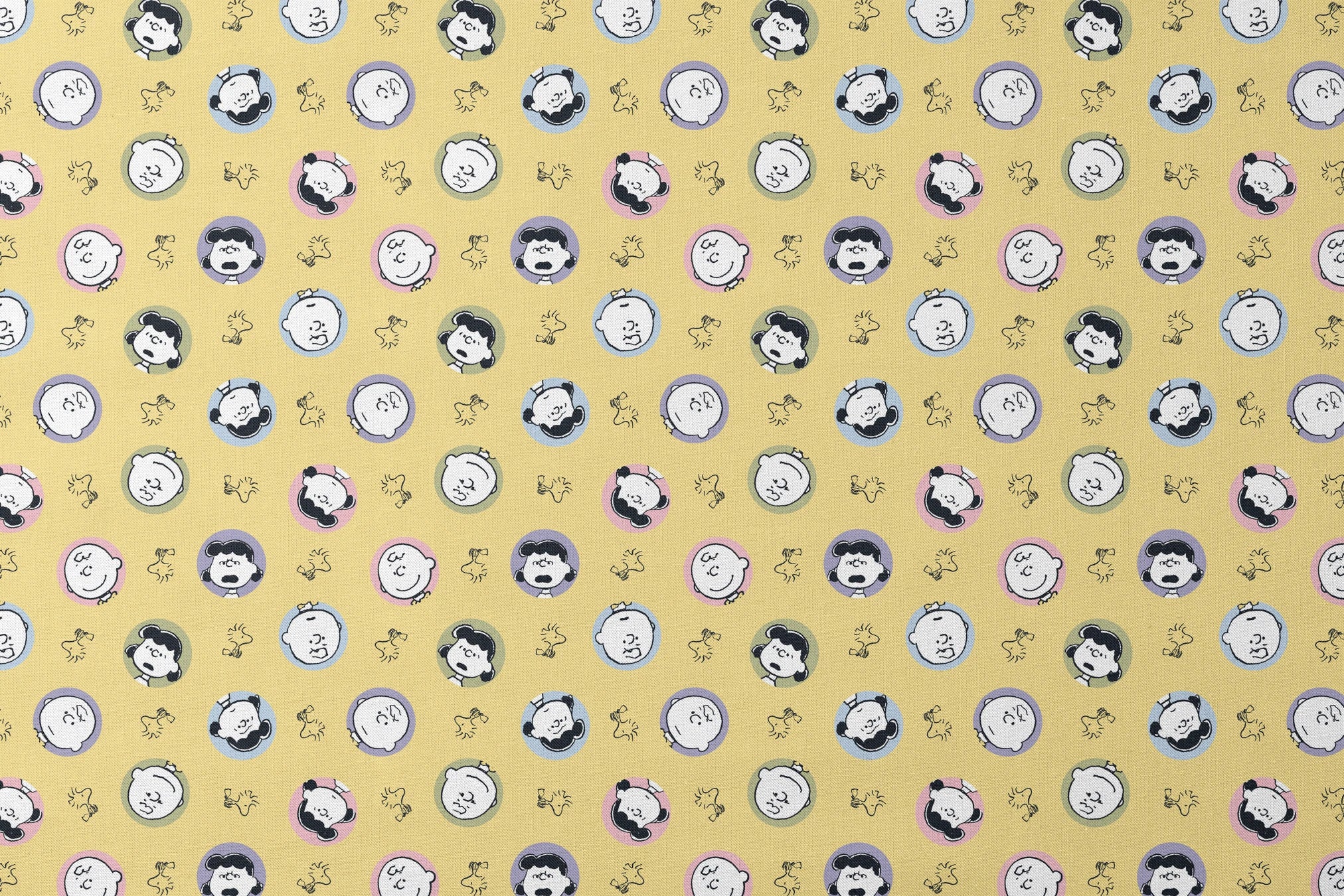 Peanuts characters pattern with Charlie Brown and friends in circular frames on yellow background with Woodstock silhouettes designs flat mockup
