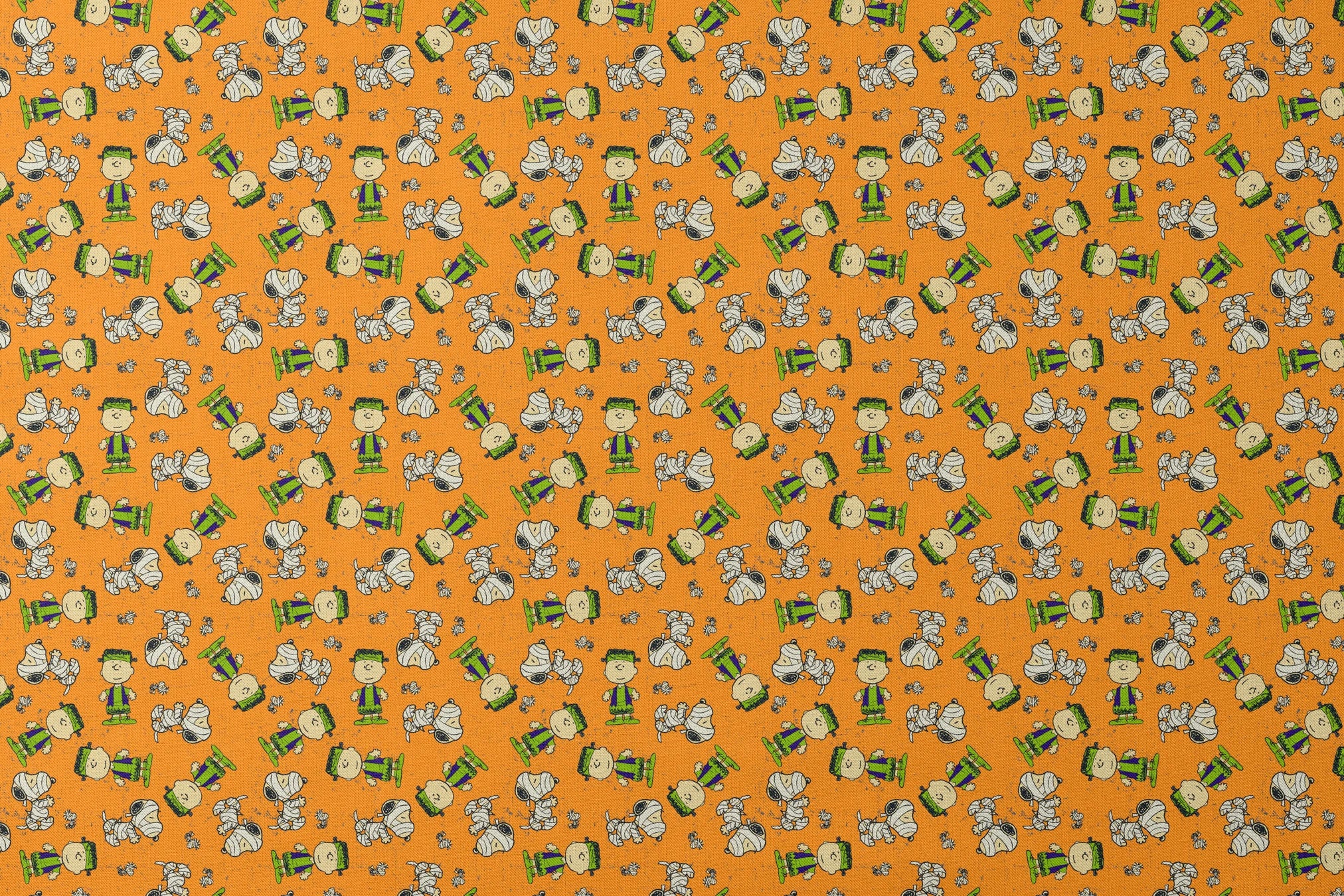 Peanuts characters pattern on orange background with Charlie Brown, Snoopy, and friends scattered throughout designs flat mockup