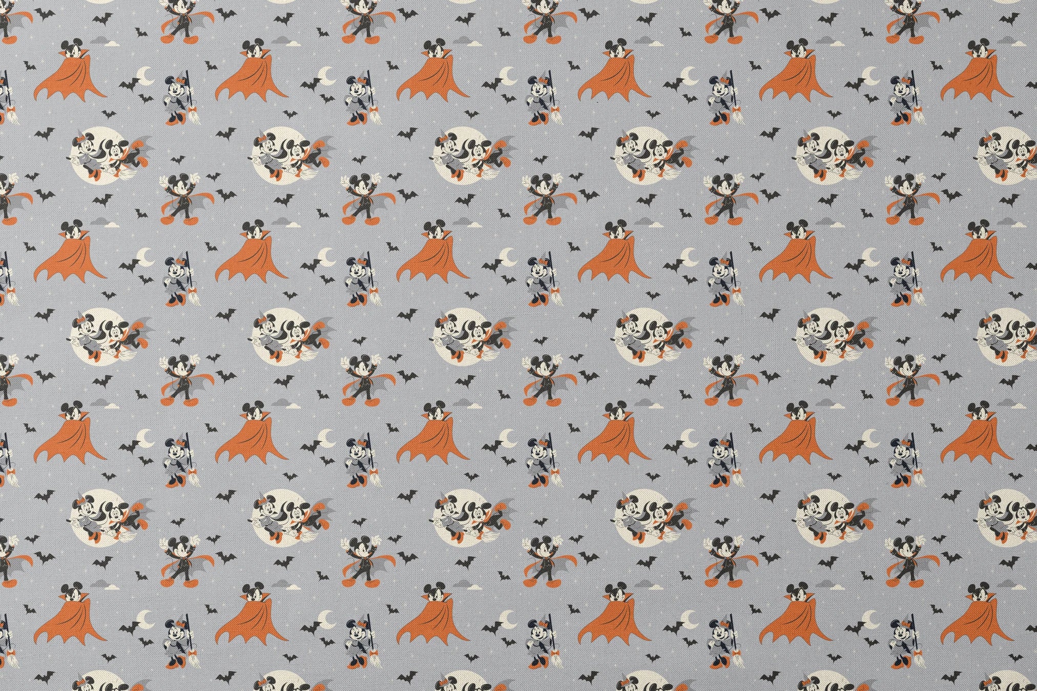 Mickey and Minnie Mouse in Halloween costumes on gray background with bats and moons, orange capes and spooky theme. designs flat mockup