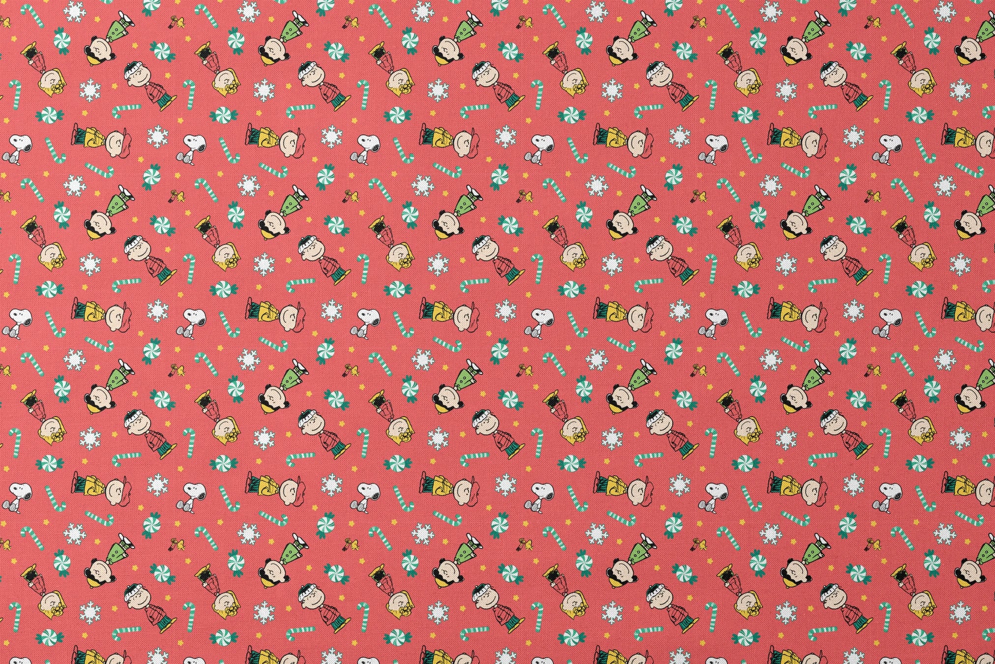 Festive Peanuts cartoon pattern with Charlie Brown characters, candy canes, snowflakes, and peppermints on red background designs flat mockup