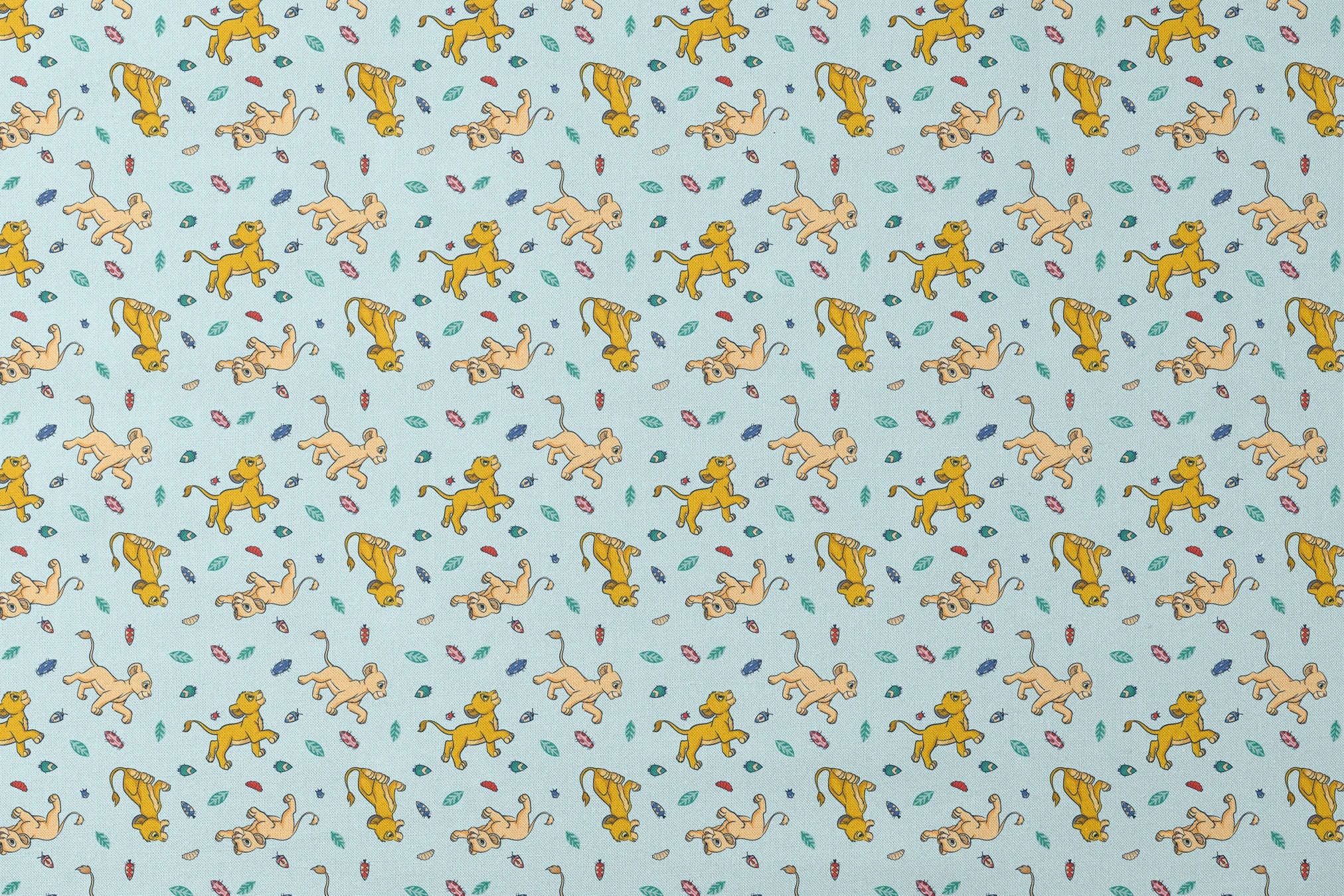 Lion cubs playing on light blue background with colorful leaves and plant elements scattered throughout designs flat mockup