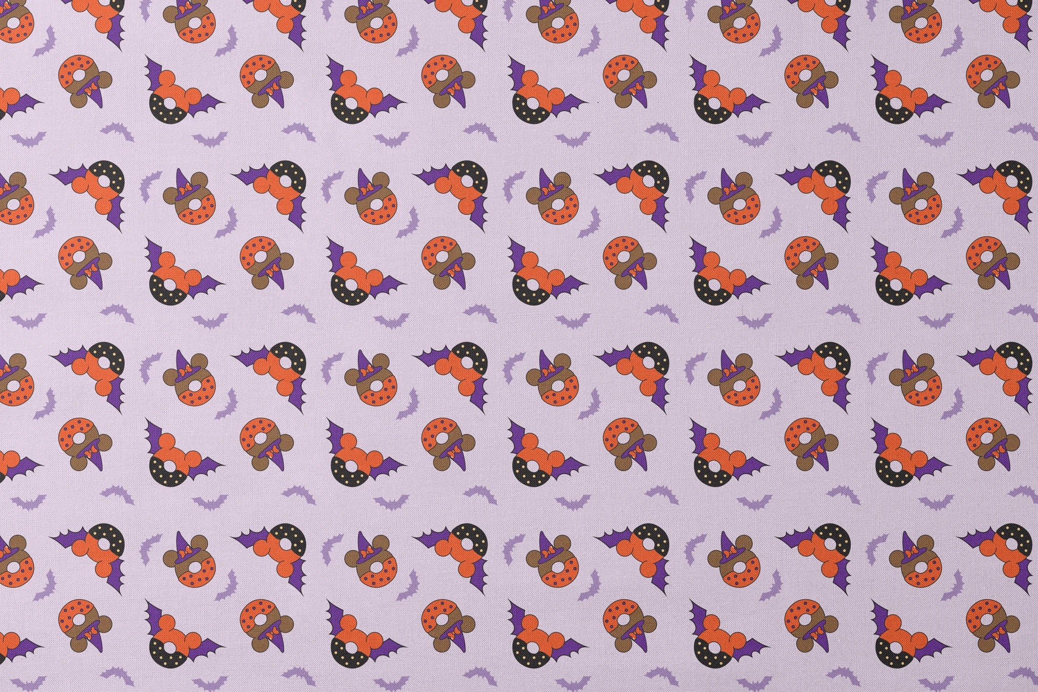 Disney Halloween-themed pattern with orange and black donuts, purple bat wings, and light purple bats on lavender background designs flat mockup