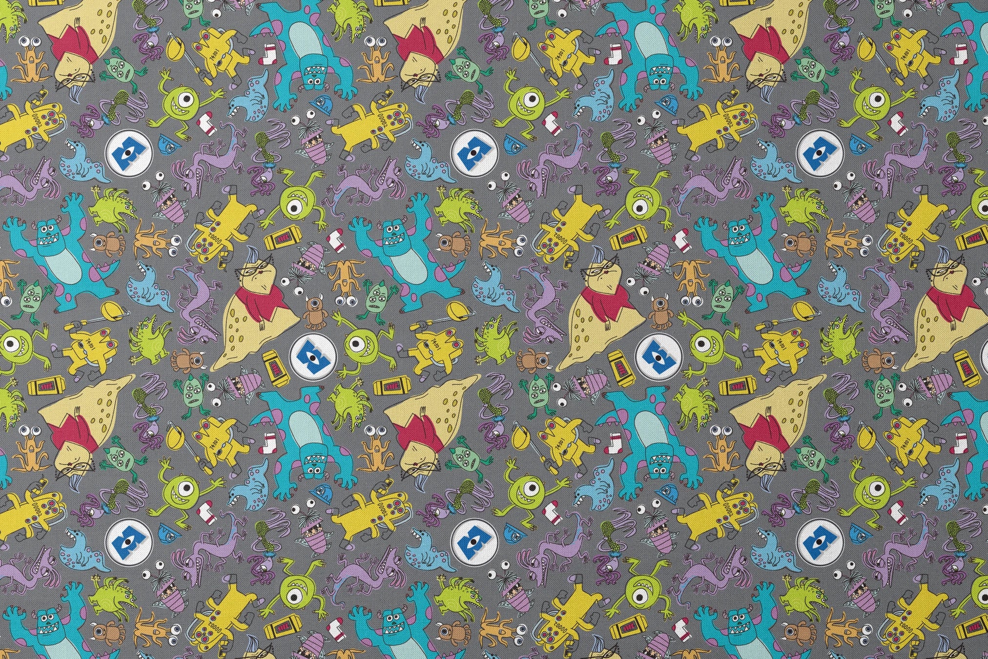 Colorful Monsters Inc pattern with various whimsical creatures in yellow, blue, green, and purple on a gray background. designs flat mockup