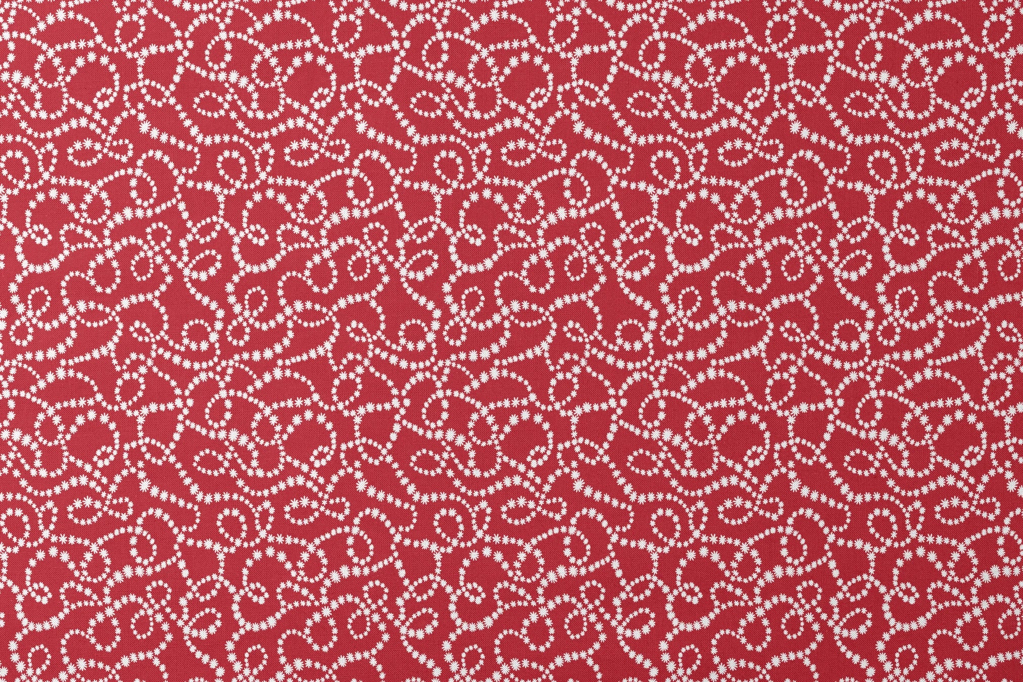 White dotted swirl pattern on rich red background creating decorative curving lines designs flat mockup