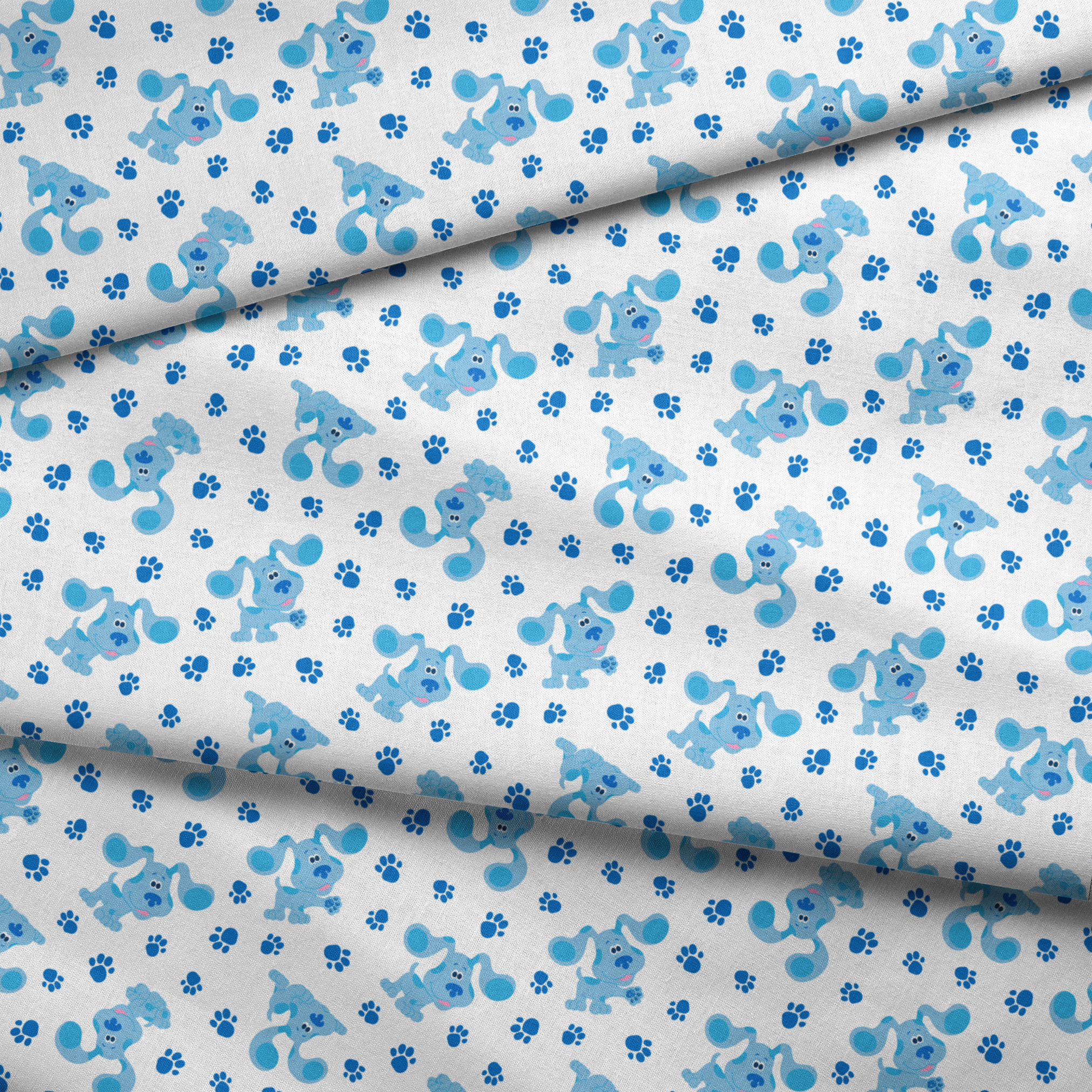 Blue cartoon puppies with floppy ears scattered among paw print pattern on white background fabric fold mockup