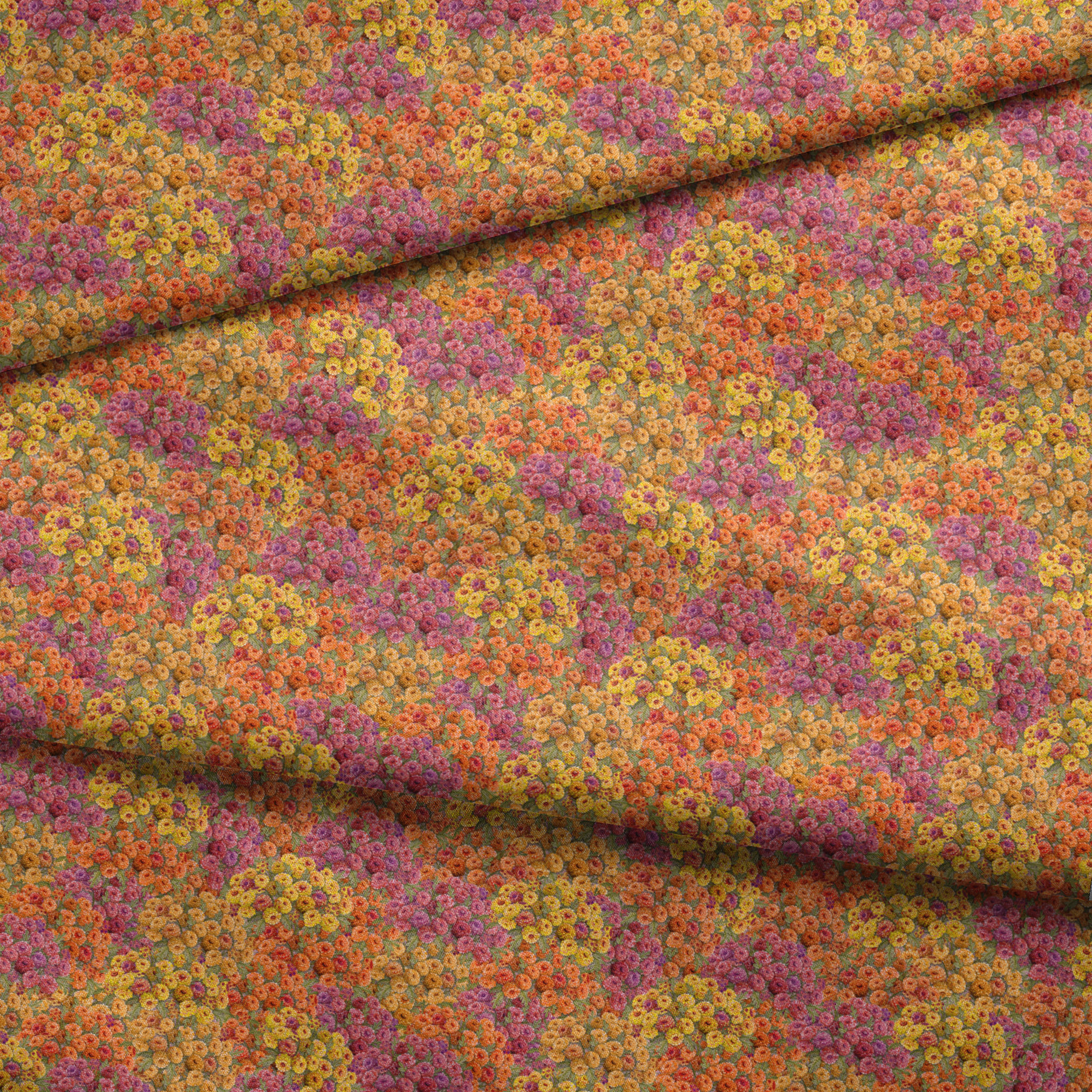 Dense floral fabric featuring orange, gold, pink, and plum zinnias in a packed all-over pattern by Nicole Tamarin. fabric fold mockup