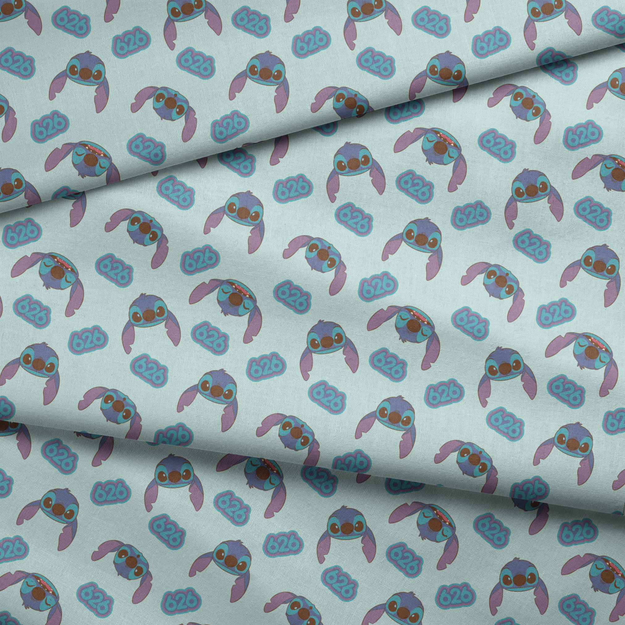 Blue cartoon creatures with large ears and swirl patterns on light teal background fabric fold mockup