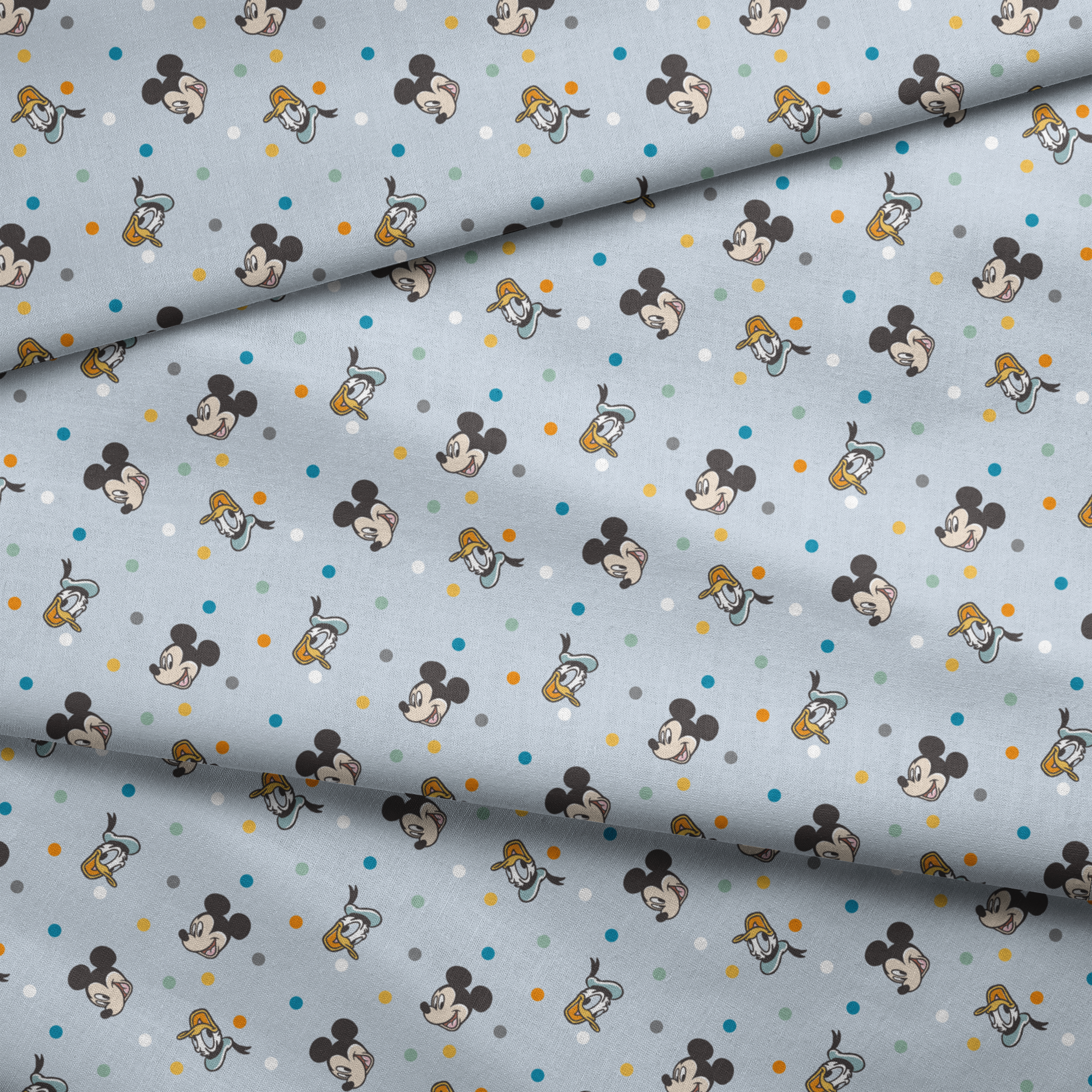 Disney character pattern with Mickey Mouse and Donald Duck heads scattered on light blue background with colorful polka dots fabric fold mockup