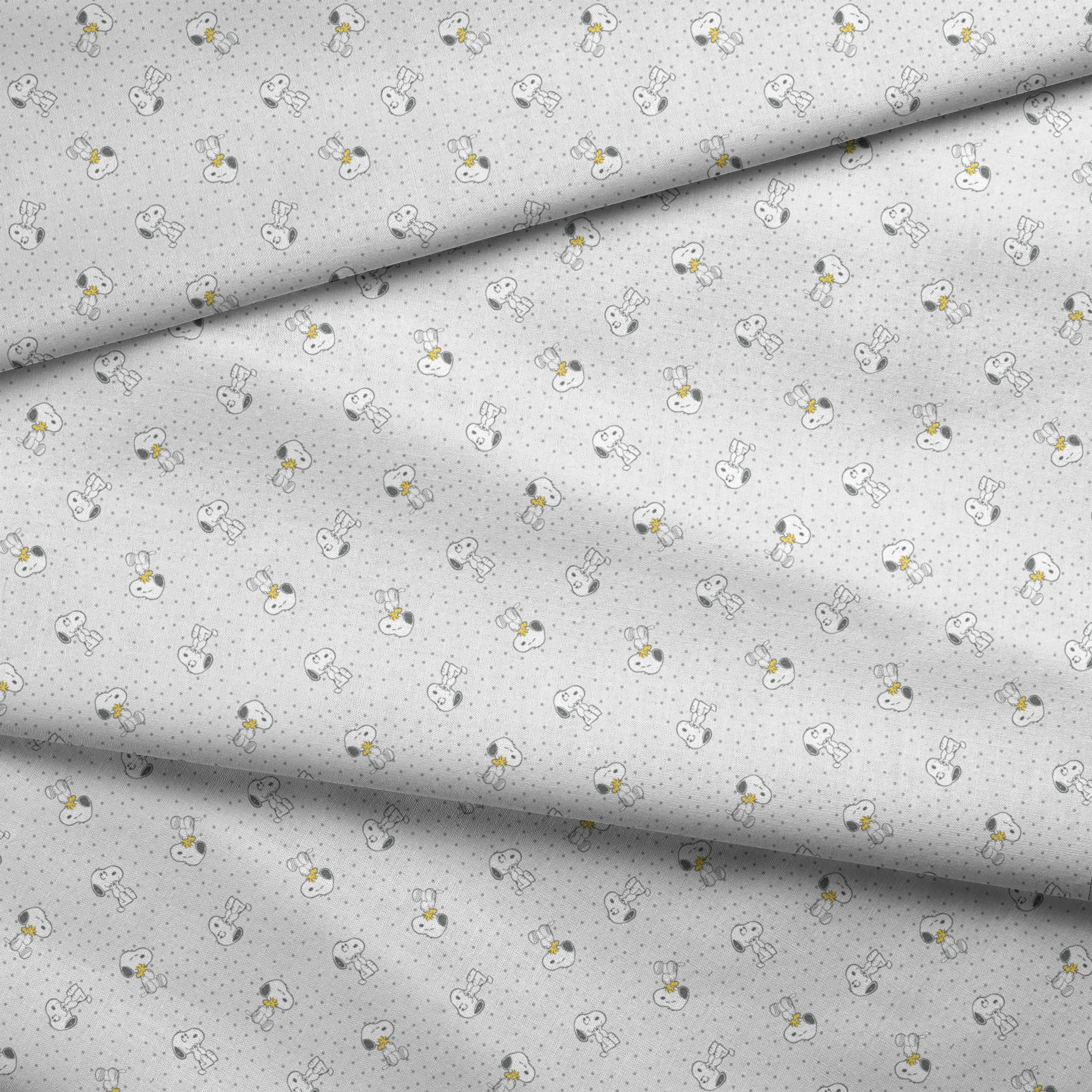 Snoopy and Woodstock on polka dot background in a repeating pattern fabric fold mockup