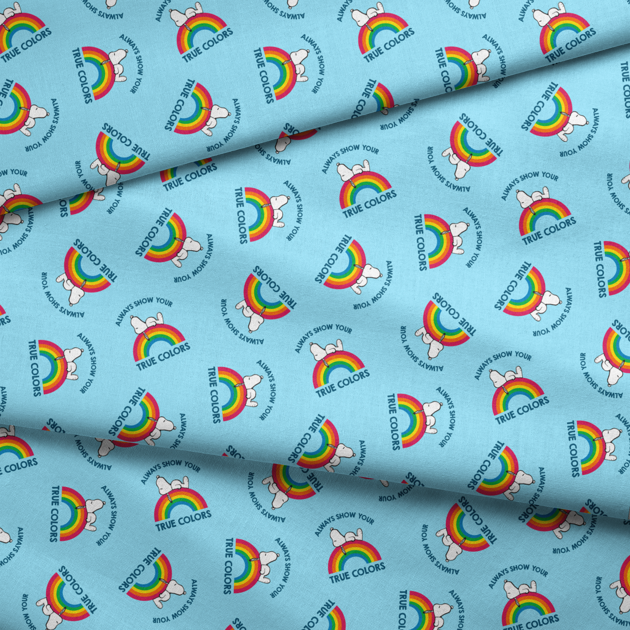 Rainbow Snoopy pattern on light blue background with white clouds and "TRUE COLORS" and "ALWAYS SHOW YOUR" text repeated throughout design fabric fold mockup