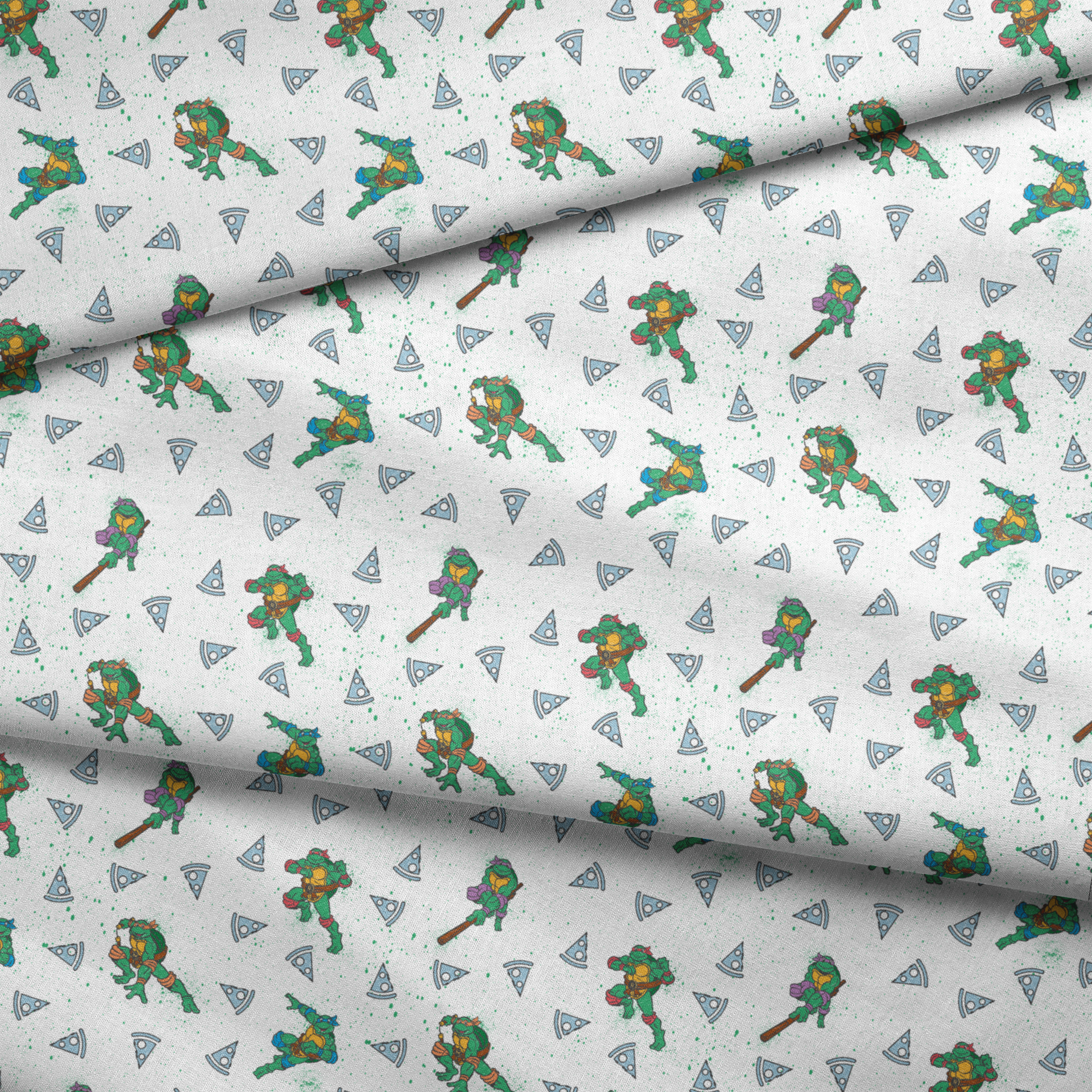 Teenage Mutant Ninja Turtles in action poses scattered among pizza slices on white speckled background fabric fold mockup