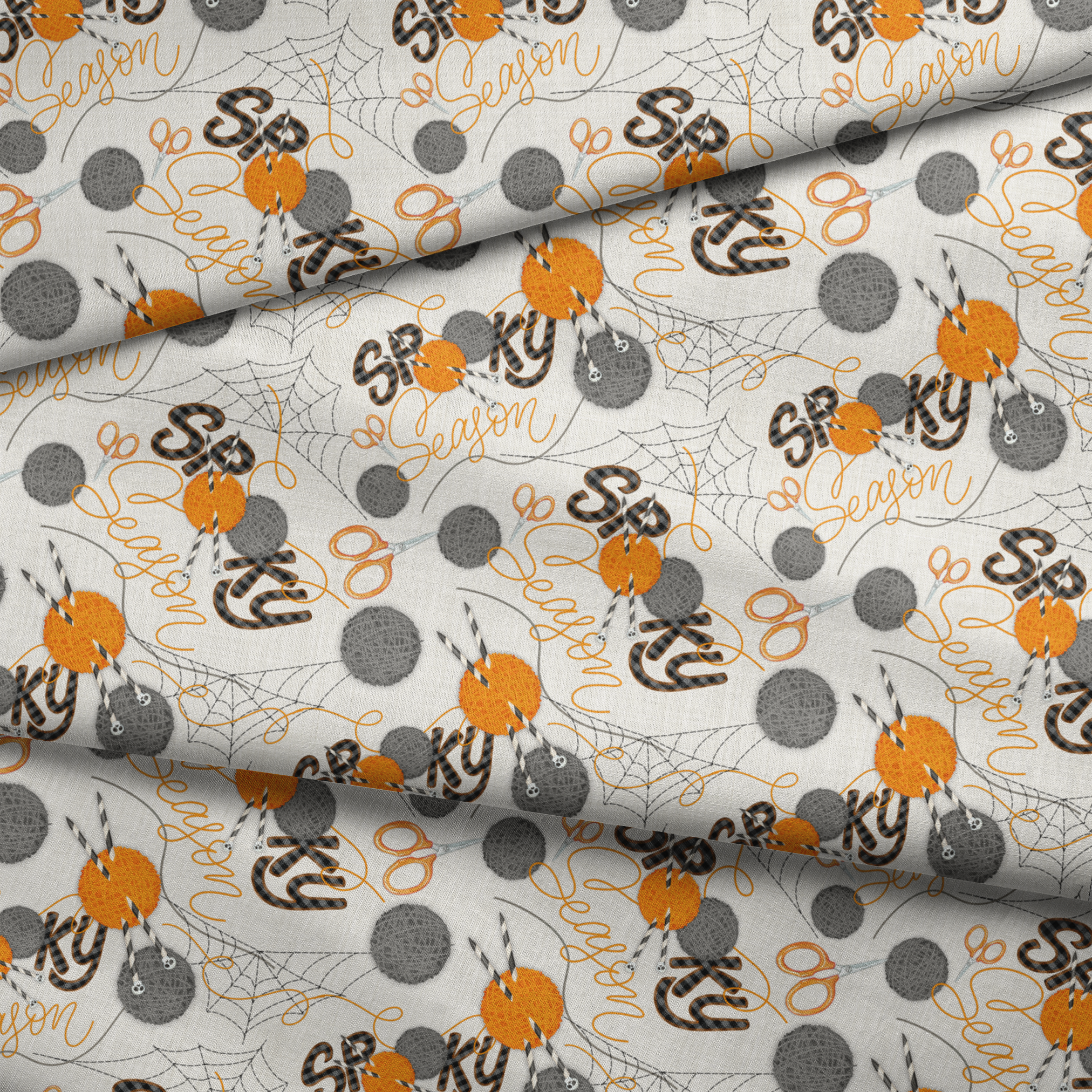 Halloween design by Nicole Tamarin featuring orange and gray yarn balls, scissors, spiderwebs, and “Spooky Season” lettering on a cream background. fabric fold mockup