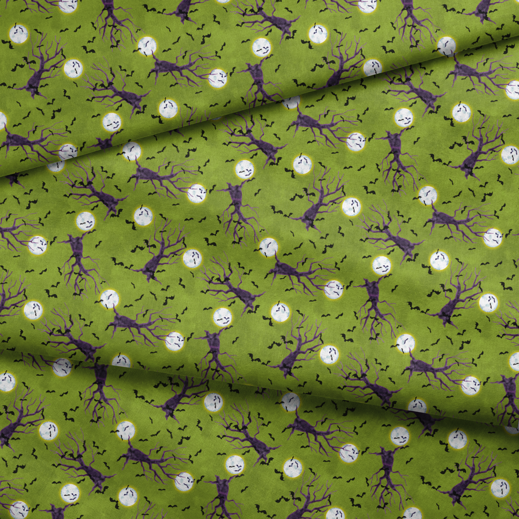 Halloween fabric design with purple haunted trees, bats, and glowing moons on a green background, illustrated by Nicole Tamarin. fabric fold mockup