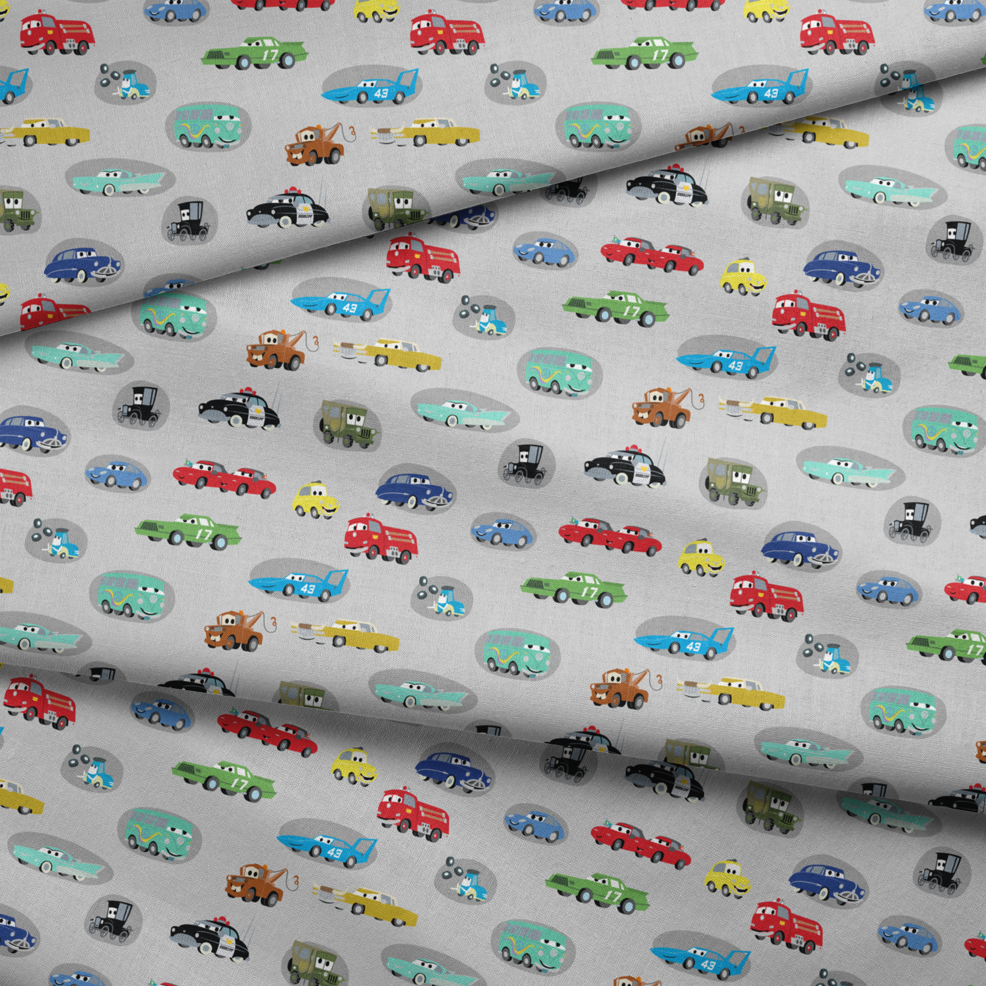 Various cartoon toy cars and vehicles in different colors (red, blue, green, yellow) displayed against a gray background with cute animated faces. fabric fold mockup