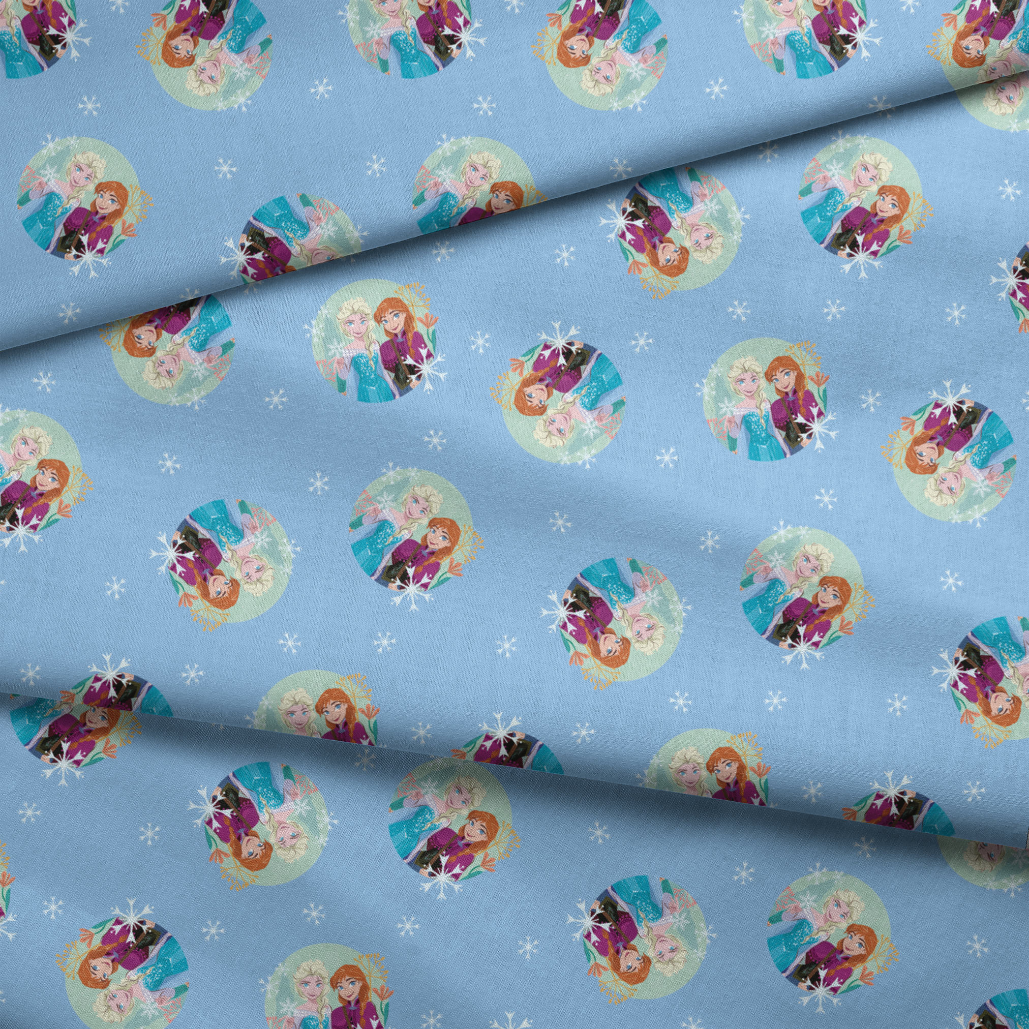 Light blue background with repeating circular motifs of "Frozen" characters and snowflakes in a decorative pattern fabric fold mockup