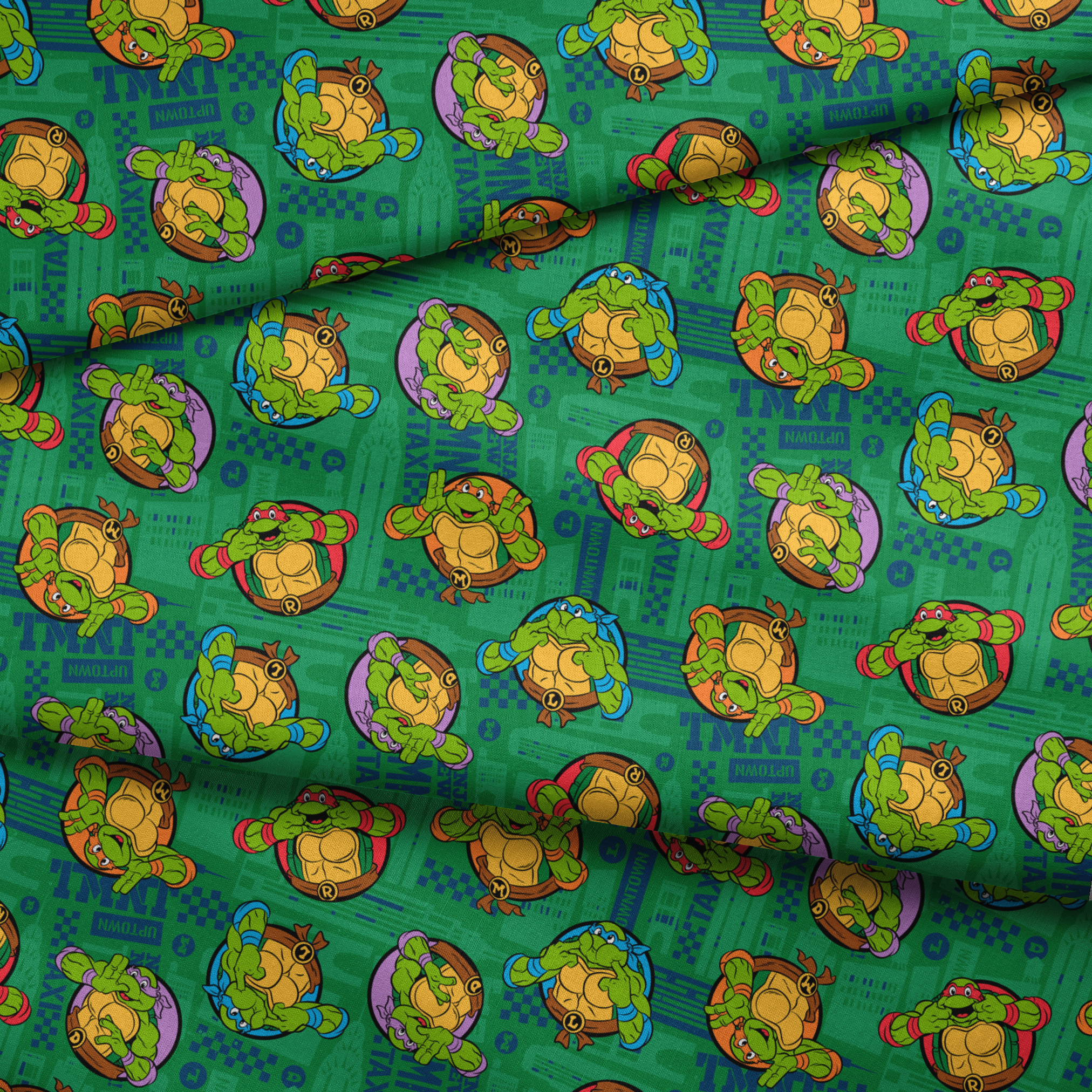 Teenage Mutant Ninja Turtles cartoon characters on green patterned background fabric fold mockup