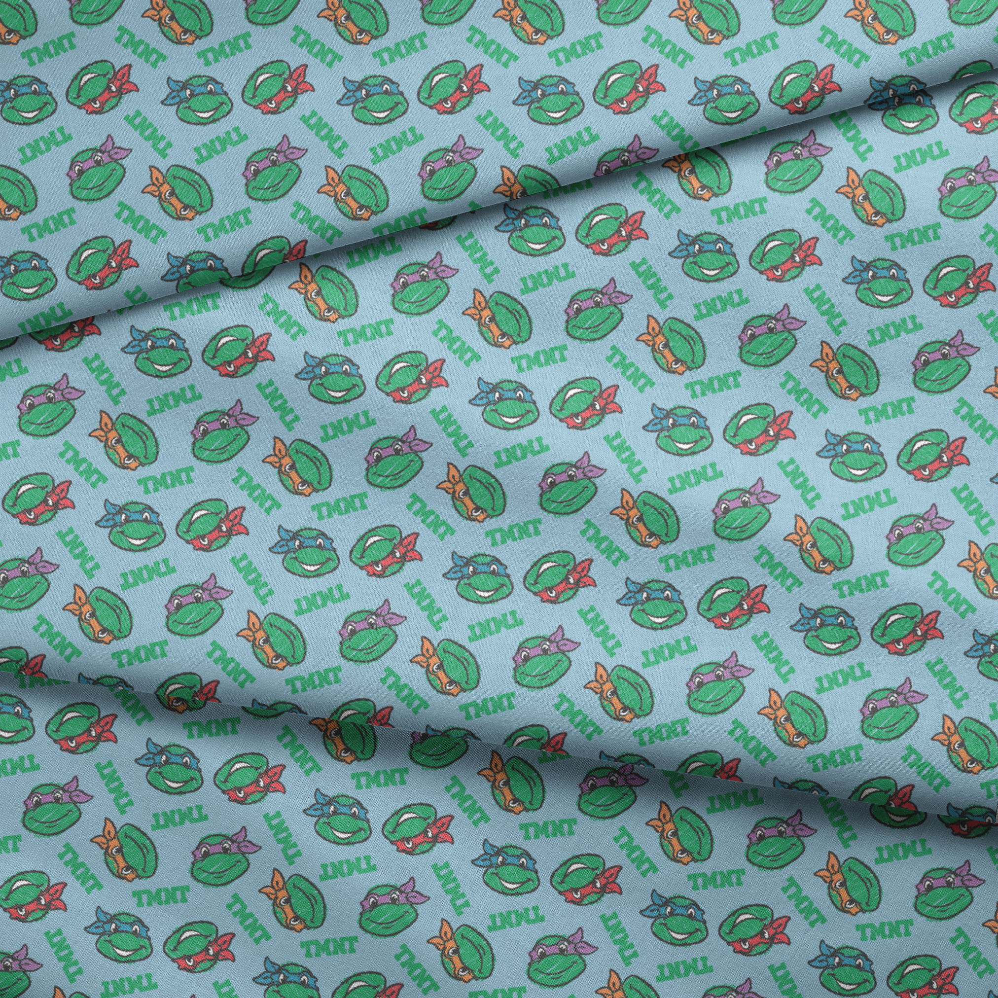 Cartoon pattern of Teenage Mutant Ninja Turtles faces with colored masks on light blue background fabric fold mockup